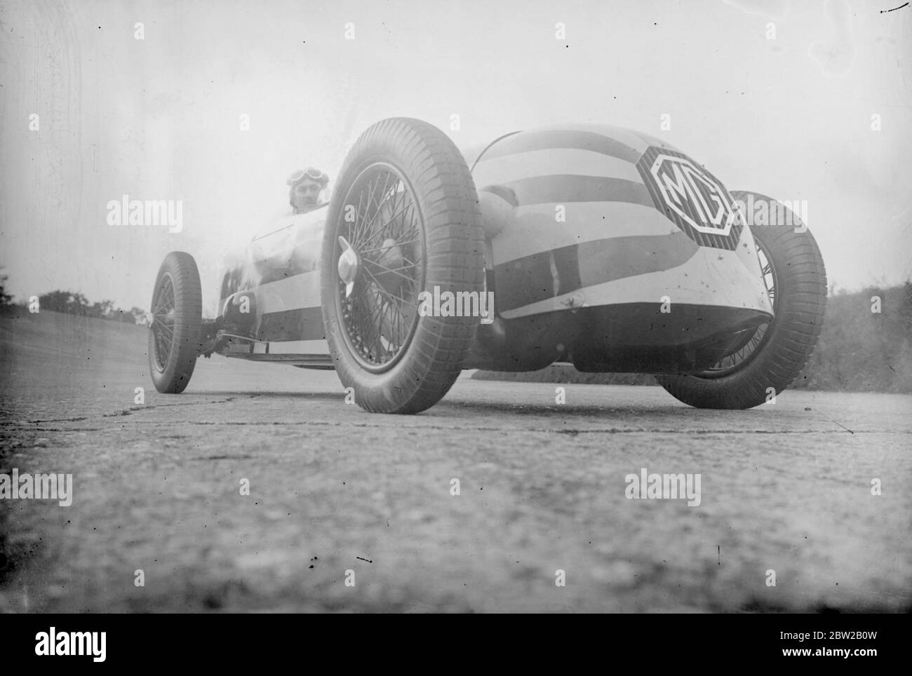 Le capitaine George Eyston, le célèbre pilote de course, teste sa nouvelle voiture de course à tête ogive Magnette géante sur le circuit de course Brooklands à Weybridge, Surrey, dans lequel il tentera d'établir un nouveau record du monde pour les voitures de 1100 cc. La voiture fait partie d'une équipe qui sera en compétition dans la course Empire Trophy et la course de 500 miles à Brooklands cette année. En roulant sur la piste, la voiture qui est rayée marron et jaune ressemble à une comète. [Garages Morris, MG] 20 avril 1934 Banque D'Images