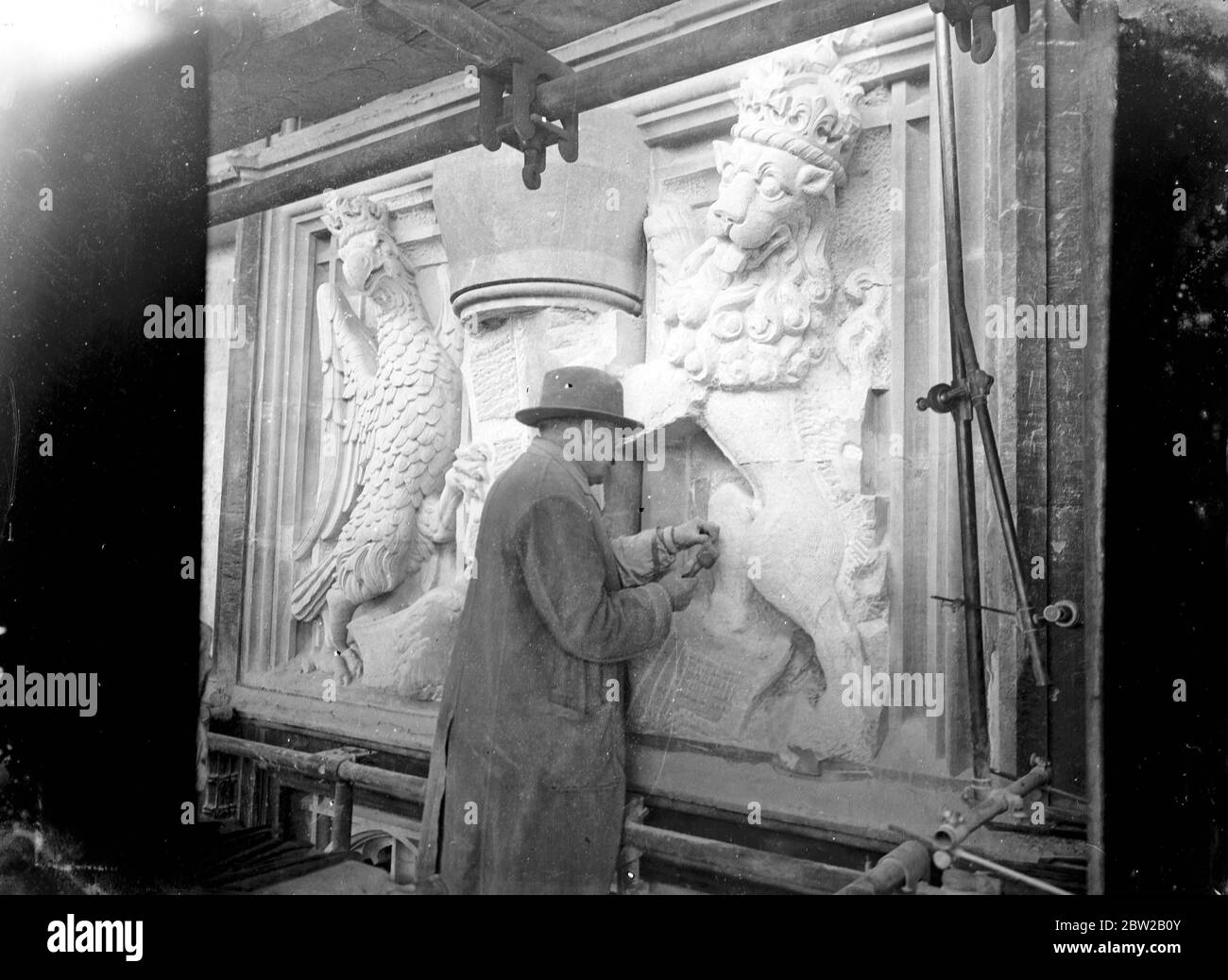 Un sculpteur travaillant sur un relief de base héraldique [Royal Supporters of England / Royal Arms of England. [Lion et aigle] 30 s. Banque D'Images