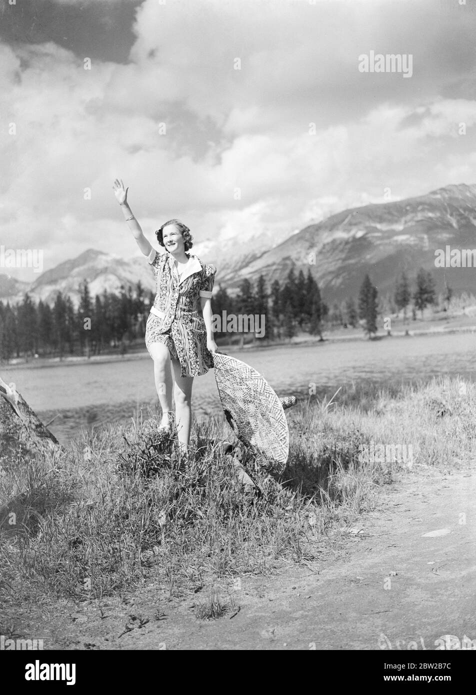 Salutations des Rocheuses canadiennes. Un charmant vacanciers délasse son chapeau géant et salue chaleureusement le lac Mildred, dans le parc national Jasper. Montagnes Pyramid et Old Man en arrière-plan. 24 juin 1939 Banque D'Images