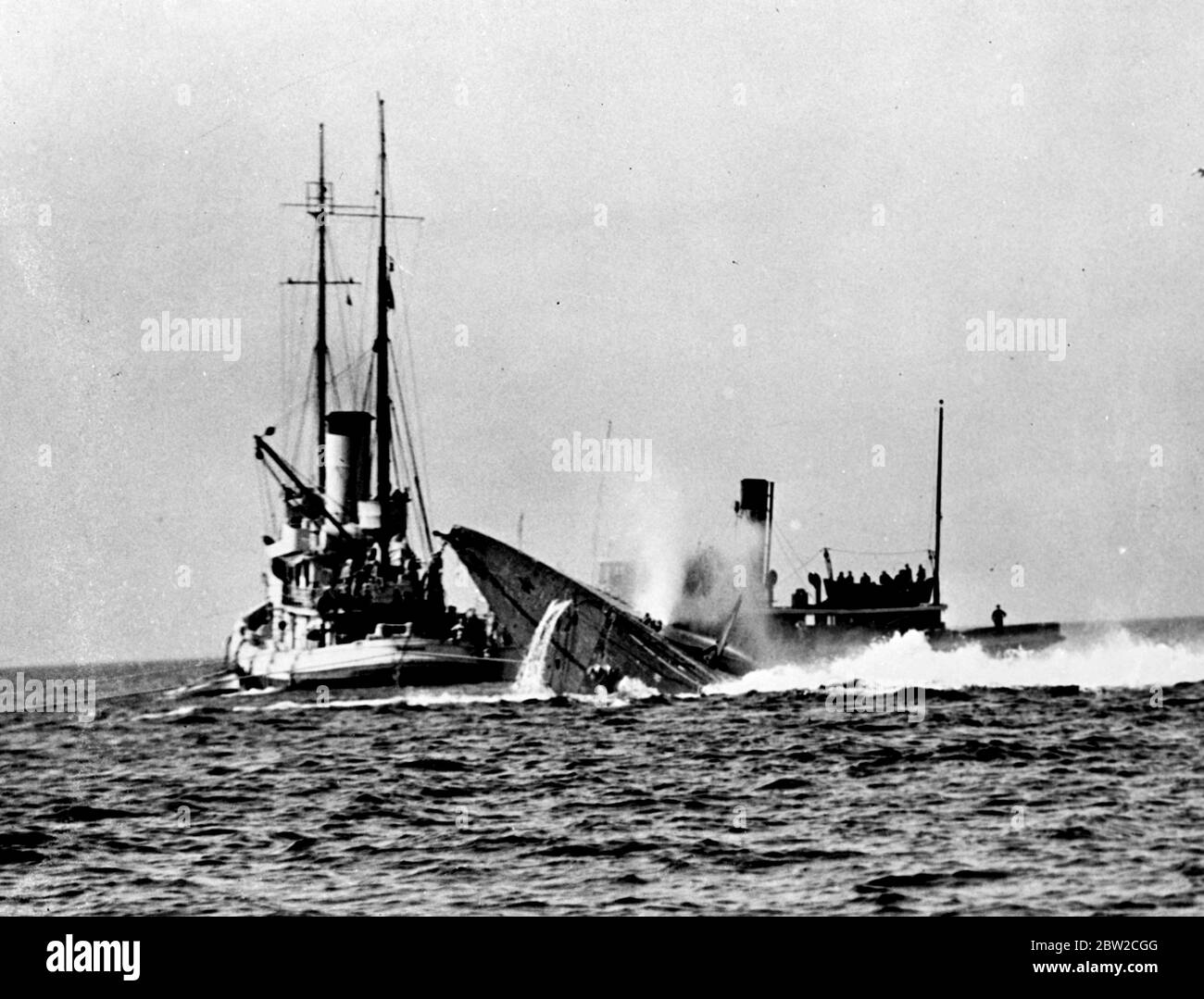 Le sous-marin américain malade Squalus et ses 36 morts [?] Ont été amenés à la surface au large de Portsmouth, New Hampshire dans le dernier des trois ascenseurs qui l'ont élevée par étapes faciles des 40 brasses d'eau dans laquelle elle a coulé. L'arc du Squalus brisant la surface avec un angle de 90 degrés par rapport au port. Le faucon du navire de récupération et un remorqueur sont vus en arrière-plan. 29 août 1939 Banque D'Images