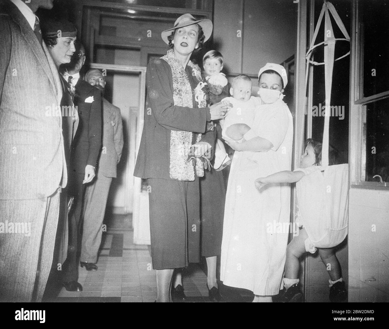 La princesse du Piémont, épouse du prince héritier italien, a inspecté à Paris l'École de Puericulture, boulevard Brune, où est donnée la formation en matière de protection de l'enfance. La princesse, sœur du roi Léopold, prolonge son séjour à Paris après le dévoilement du mémorial à son père, le roi Albert des Belges. La photo montre la princesse se faire des amis avec des bébés à cette école de Puericulture à Paris. 14 octobre 1938 Banque D'Images
