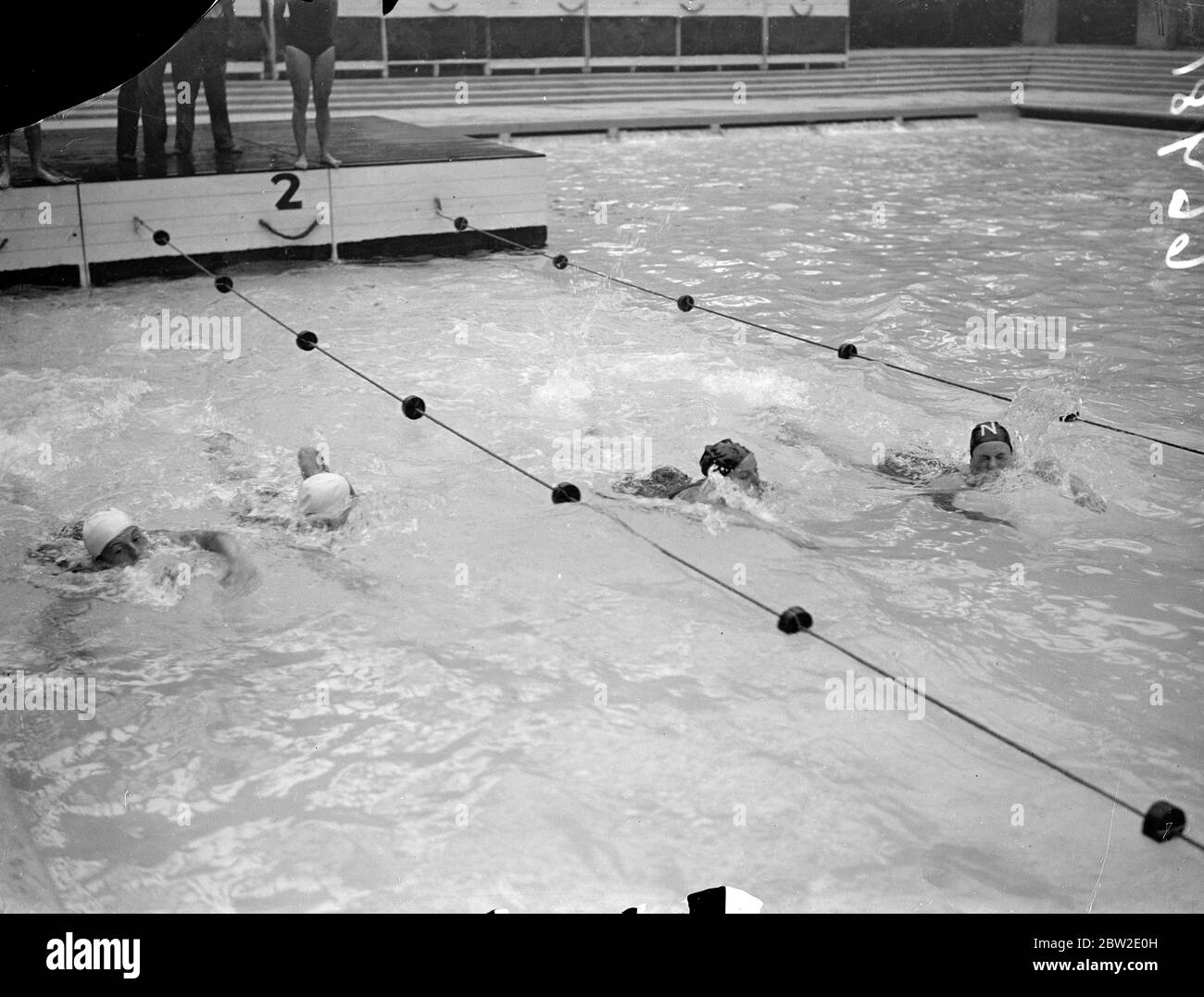 L'équipe allemande de nageurs et de plongeurs qui rencontreront l'Angleterre en résumé des épreuves de plongée et de water-polo à Wembley. L'équipe allemande relaie en action au bassin de Wembley. 23 juillet 1937 Banque D'Images
