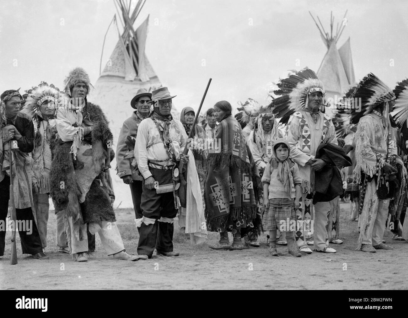 La tournée royale du Canada et des États-Unis par le roi George VI et la reine Elizabeth , 1939 le roi et la reine visitent Regina, capitale de la Saskatchewan . Ils sont accueillis par les chefs indiens des minerais , Sioux , Saultaus , Assiniboines et autres tribus . Les chefs de l'Inde avec leurs plumes et les tomahawks . Banque D'Images