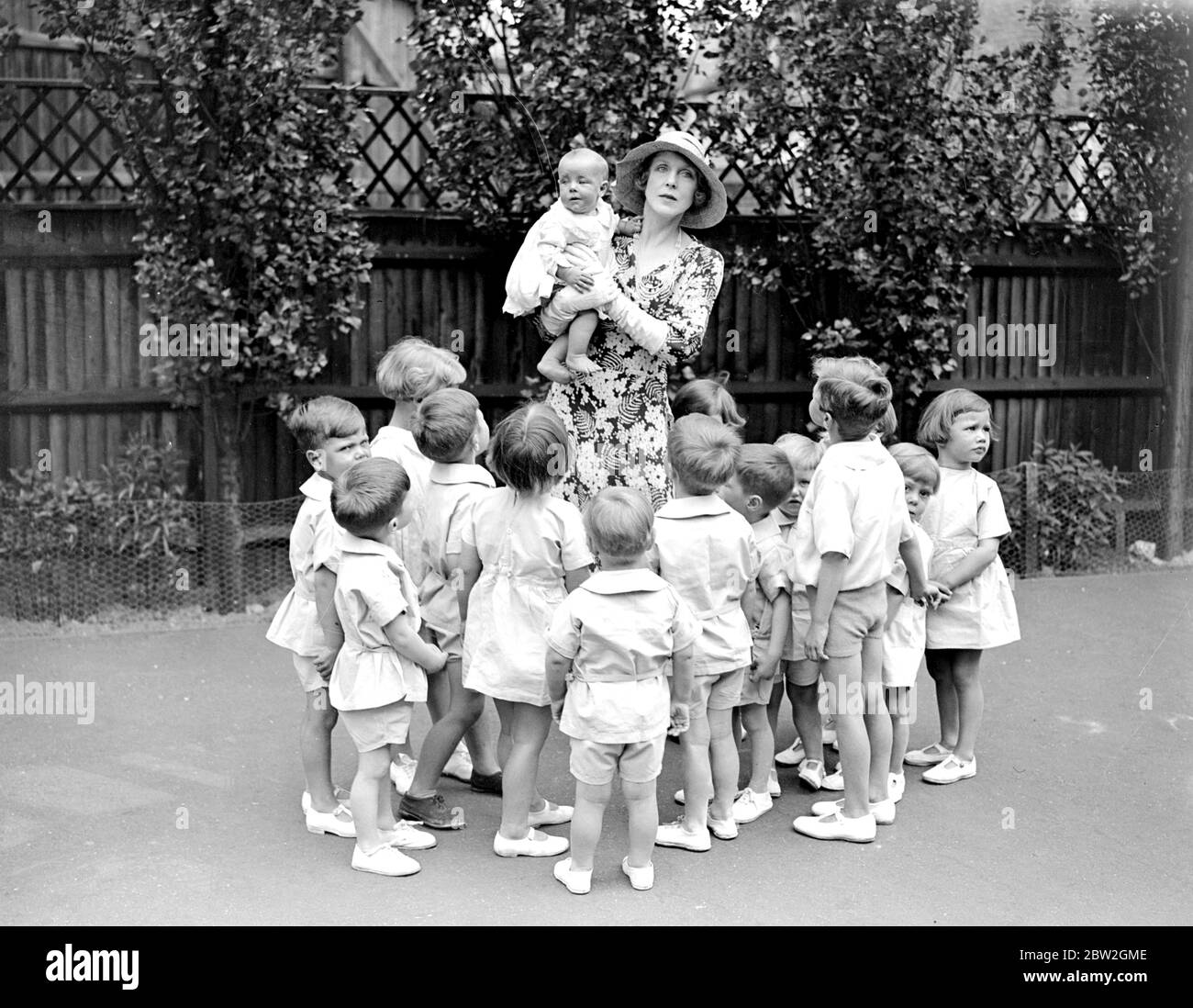 Lady Diana Duff Cooper avec les bébés de la pépinière de jour Barnes and Mortlake. 28 juin 1932 Banque D'Images