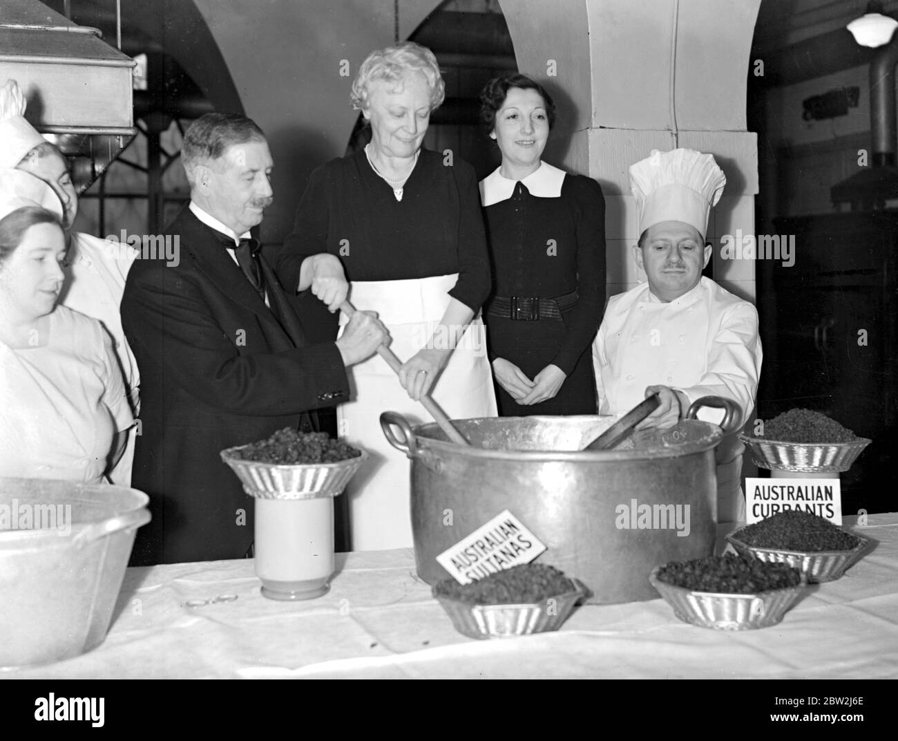 Noël 1938. Le maire Lord et la madéesse aident le chef de la Maison de la Maison, M. E. Oyez, à éstider et à goûter le Pudding de Noël. 1er décembre 1938 Banque D'Images