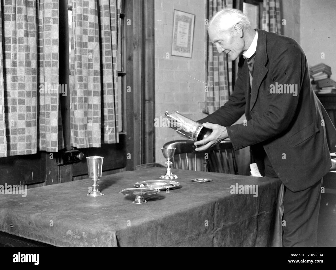 Le Reverend Wiltshire verse le vin. 1934 Banque D'Images