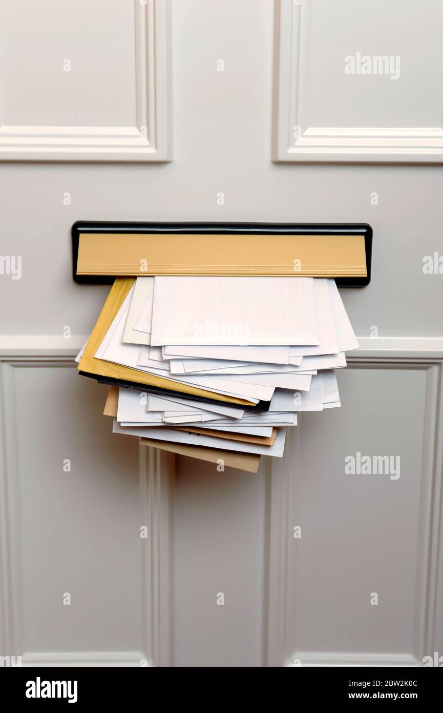 L'intérieur d'une porte d'entrée avec une boîte aux lettres pleine de courrier Banque D'Images