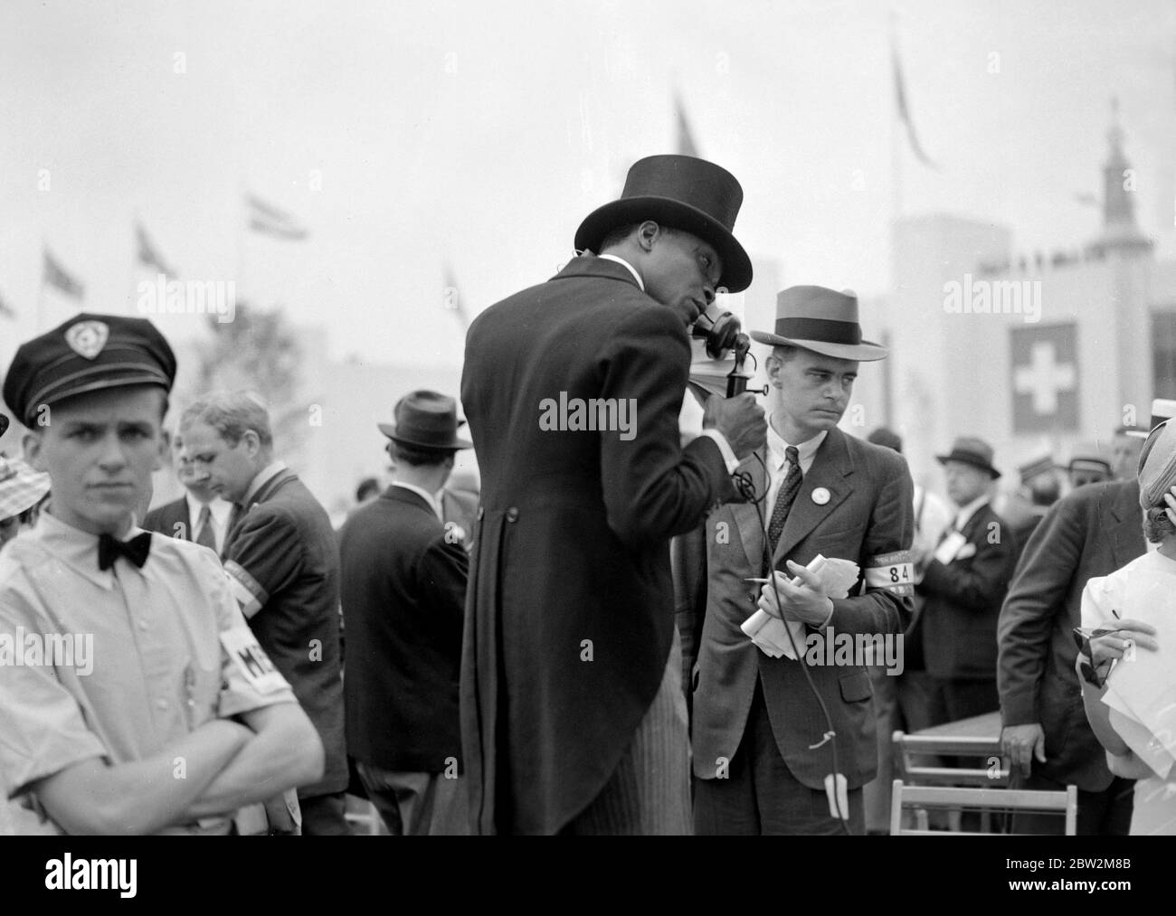 La tournée royale du Canada et des États-Unis par le roi George VI et la reine Elizabeth , 1939 le roi et la reine à l'exposition universelle de New York. Un journaliste de couleur (noir) en robe du matin complète téléphonant à son histoire. Banque D'Images
