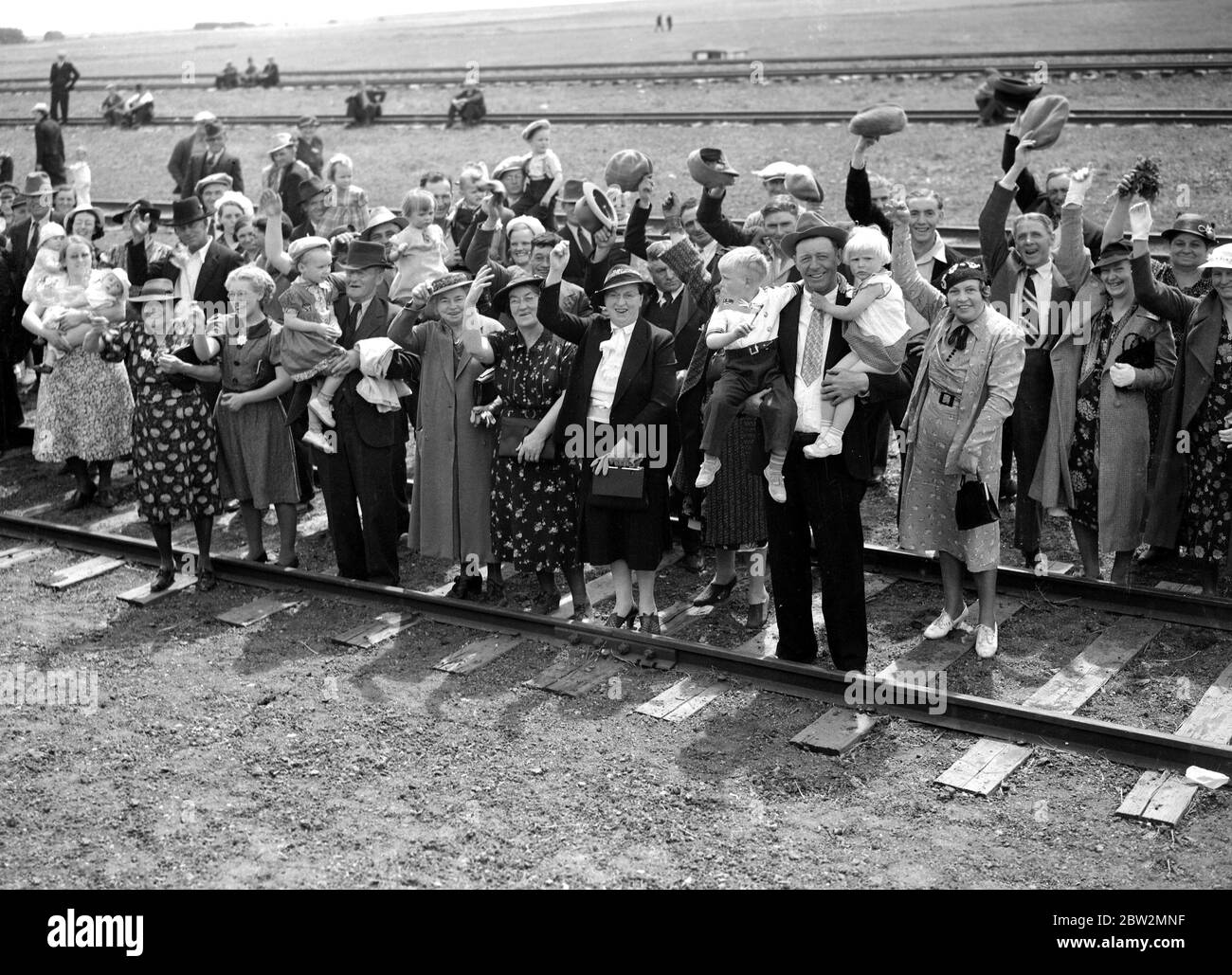 Le roi George VI et la reine Elizabeth lors de leur tournée royale des États-Unis et du Canada , 1939 UNE scène typique sur les voies ferrées, comme les agriculteurs et leurs familles , dont certains avaient parcouru des kilomètres , ont acclamé le roi et la reine lorsqu'ils passaient dans les Prairies du Canada. Banque D'Images