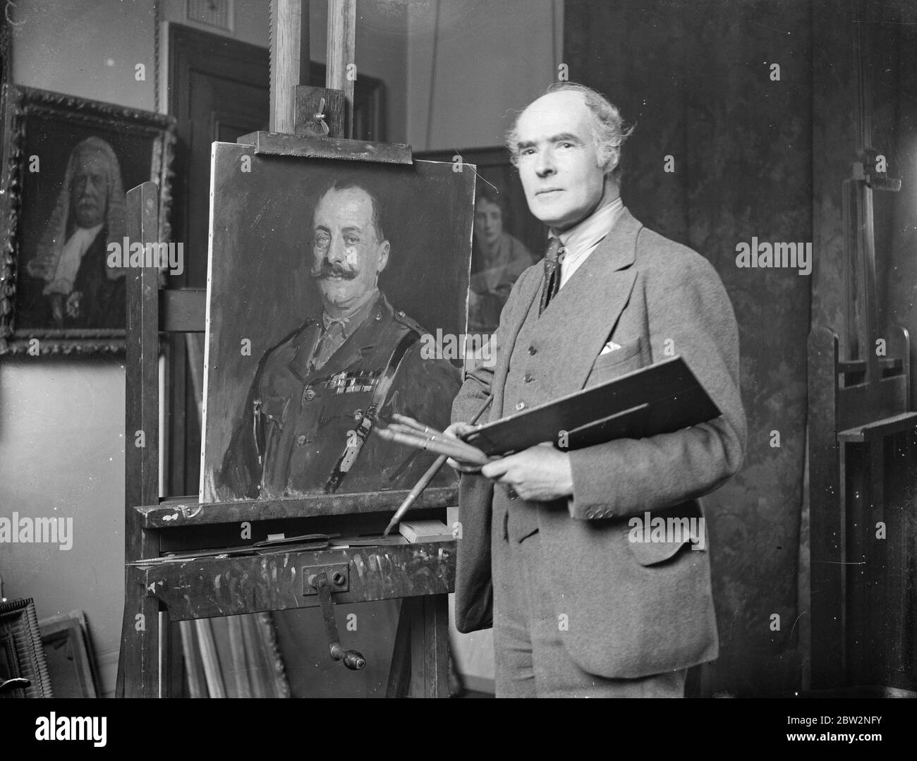 M. Reginald Eves doit soumettre à nouveau des photos à l'Académie royale . Malgré le fait que ses photos ont été rejetées l'année dernière sur le terrain que certaines de ses scènes architecturales ont été peintes sur une base photographique , M. Reginald Eves s'attend à soumettre certaines de ses œuvres comme lecture au comité suspendu de l'Académie Royale . Il est busily au travail dans son studio de préparation à l'académie . M. Reginald Eves , qui est un ardent musicien , jouant son violon dans son studio à côté de son dernier ouvrage , un portrait de Lord Fitzwilliam , qu'il peut soumettre pour l' Académie Royale de cette année . 24 février 1932 30 Banque D'Images