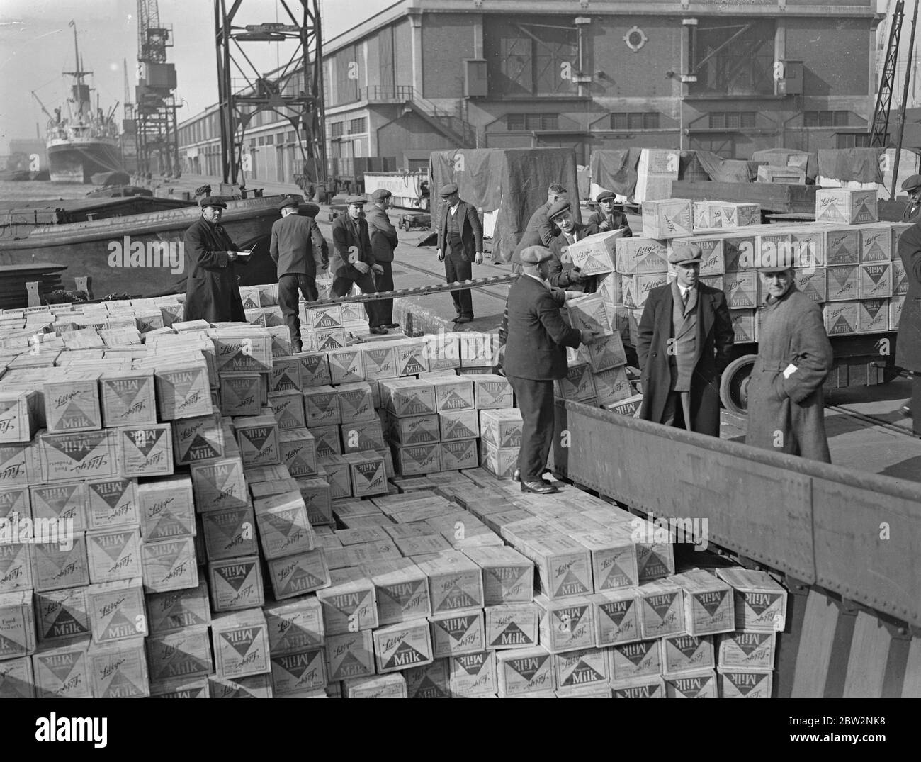 Dimanche déchargement pour échapper aux tarifs . Tous les dimanches de la journée, les quais de la Tamise ont présenté une scène d'activité sans précédent, comme les navires ont été déchargés et les marchandises transférées à des barges et à terre précipitée pour échapper aux nouvelles taxes . Déchargement du lait du président Harding le paquebot américain qui a amarré pour la première fois au King George Vdocks . 28 février 1932 30, 30, 30, 30, 30, 30, 30, 30, 30 Banque D'Images