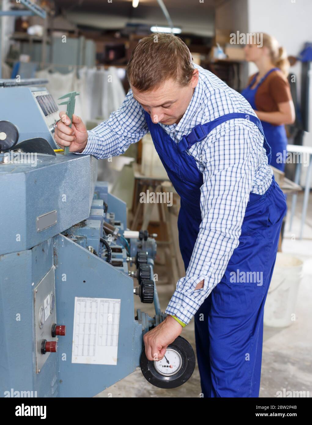 Vitrier mâle confiant travaillant sur une machine à biseauter en ligne  droite en verre dans la salle de travail Photo Stock - Alamy