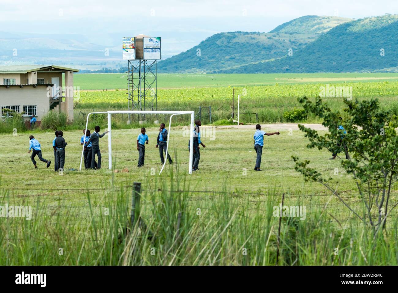 Les garçons des écoles rurales africaines jouent au football ou au football dans leurs uniformes scolaires pendant les pauses à Kwazulu Natal, en Afrique du Sud Banque D'Images