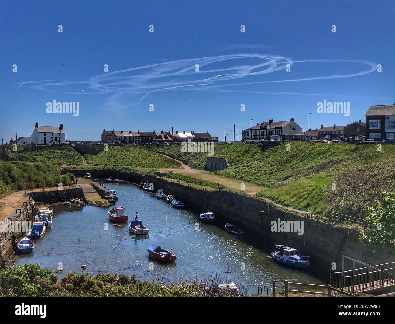 Deux avions contrefont des formes dans le ciel, comme vu du port de Seaton Sluice. Banque D'Images