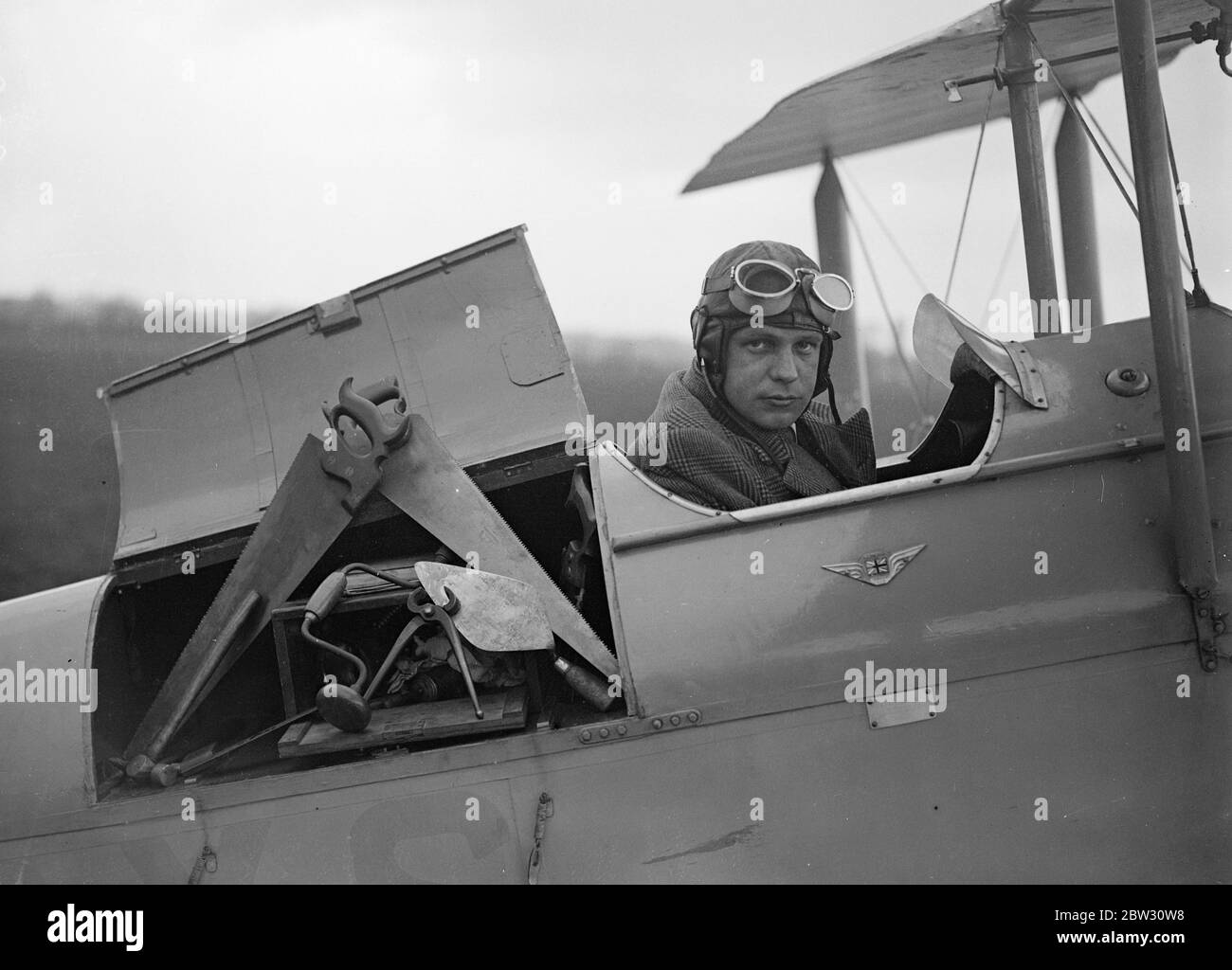 Le constructeur volant charge son avion . M. John Stark , un constructeur de Woodford Green , Essex , afin de réaliser son travail de construction dans diverses parties du pays a acquis un avion , dans lequel est monté un compartiment spécial pour le transport des outils de construction , pour qu'il puisse voyager dans le pays jusqu'à son travail . Lorsque M. Stark a un travail de construction à exécuter dans le pays, il prend son avion et le atterrit par le site et retourne à la maison par avion une fois le travail terminé . M. John Stark dans le cockpit de son avion sur le point de se mettre en chantier à Hertforshire . 29 avril 1932 Banque D'Images