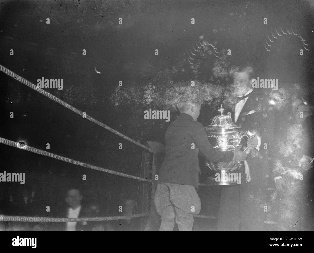 Le Prince de Galles présente une coupe de boxe . Le Prince de Galles a assisté au tournoi de boxe de courses de lads au Royal Albert Hall , Londres et a ensuite présenté les coupes . Le Prince de Galles présente la McAlpine Cup au quartier N des écuries J Lawson après que son équipe ait gagné le concours de boxe avec les écuries Newmarket . 10 février 1932 Banque D'Images