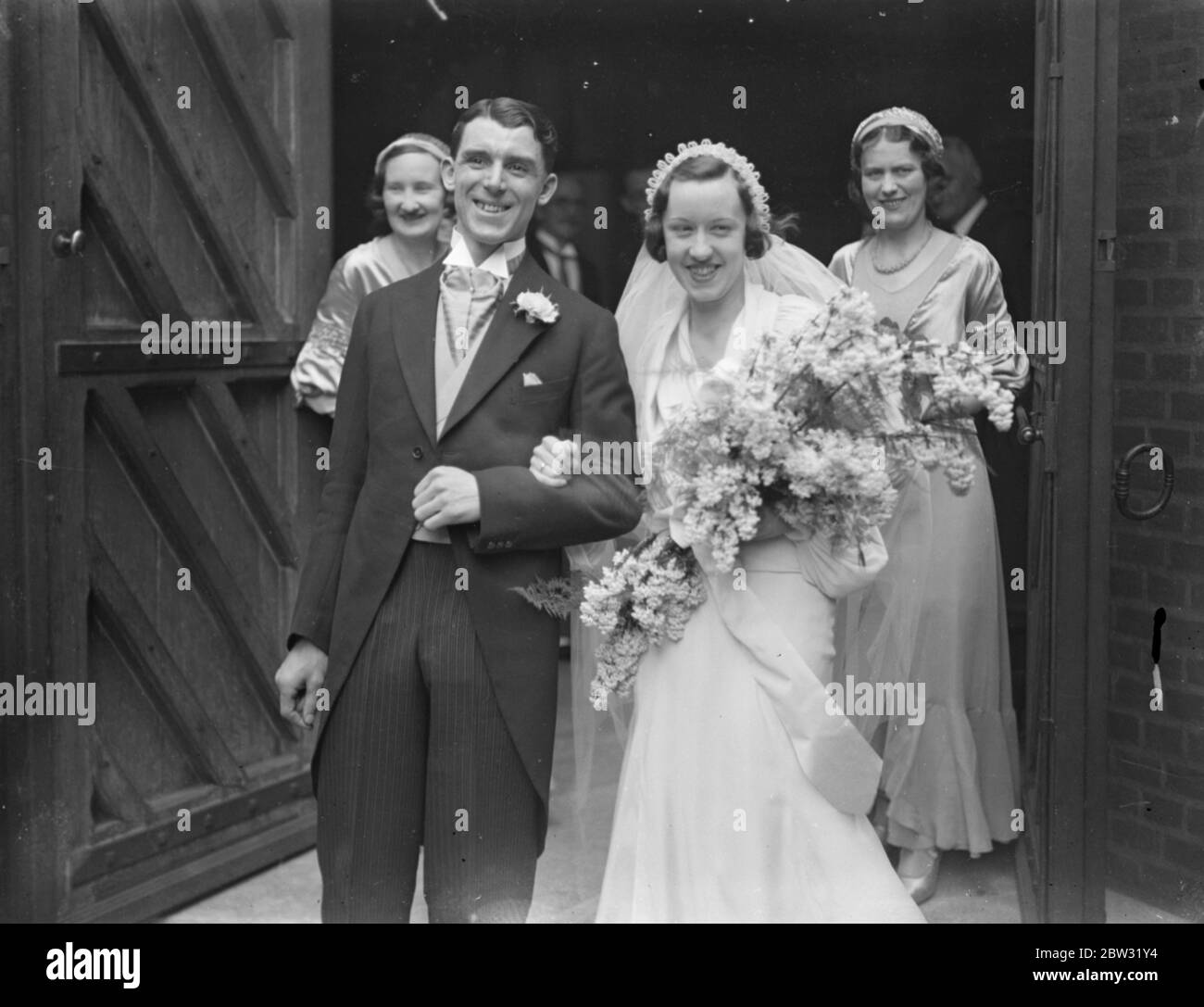Célèbres Weds Bleu d'Oxford et internationaux de Gallois . M. Ivor Thomas , l'ancien coureur d'Oxford Blue et Double First et Welsh International a été marié à Mlle Dilys Llewelyn Jones de Merrhyr Tydfil , à l'église St Mary's Grahan Street , Londres . La mariée et le marié avec les demoiselles d'honneur après la cérémonie . 5 avril 1932 Banque D'Images