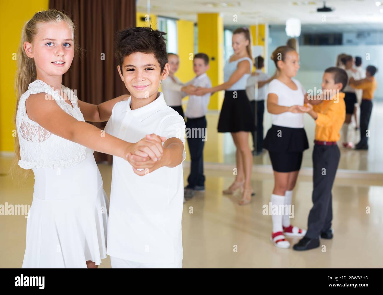 des enfants anglais souriants dansent en couple en classe Banque D'Images