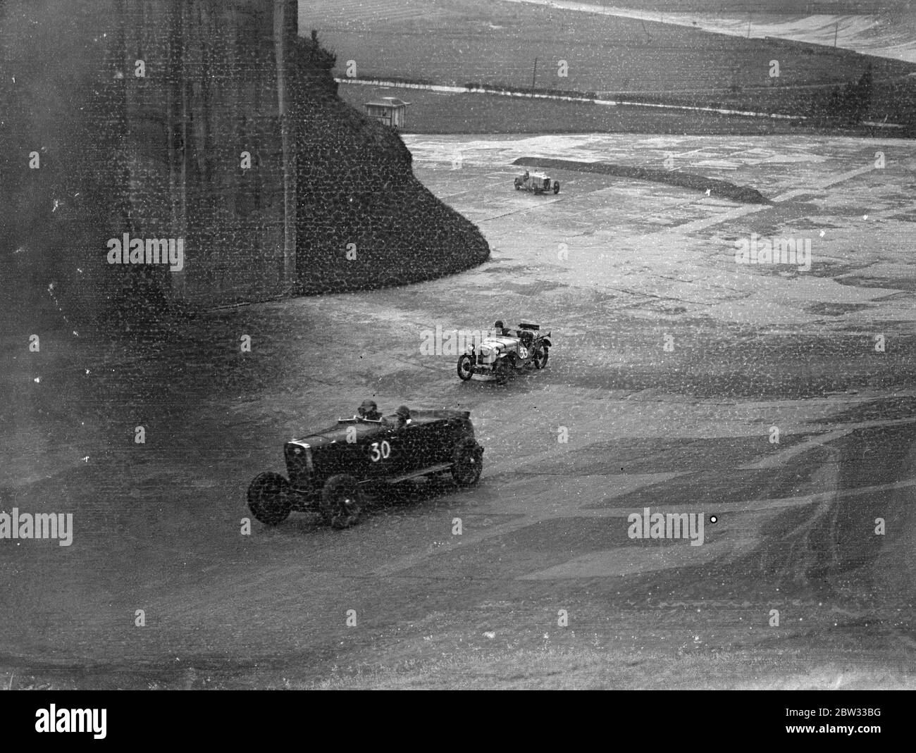 Pratique de dernière minute pour la réunion d'ouverture à Brooklands . Malgré une pluie torride , de nombreux concurrents à la réunion d'ouverture de la piste de course de Brooklands lundi ont essayé leurs voitures sur le parcours . Des concurrents qui essaient leurs voitures sous la pluie sur la piste de montagne de Brooklands . 26 mars 1932 Banque D'Images