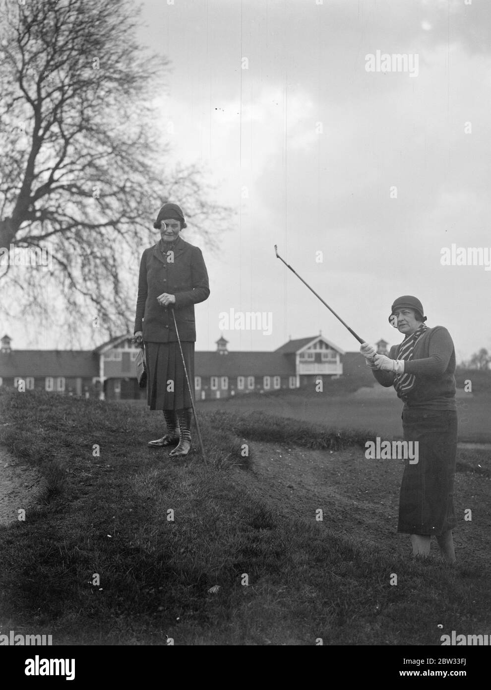 Le tournoi de golf parlementaire Dames ouvre à Ranelagh . L'association Ladies Parliamentary Golf a organisé un tournoi d'invitation au Ranelagh Club , Londres pour célébrer le 21 anniversaire de l'association , de nombreuses femmes golfeurs des cercles parlementaires y ont participé . Lady Droghoda en sortant d'un bunker surveillé par Mme Robert Fleming . 8 avril 1932 . Banque D'Images