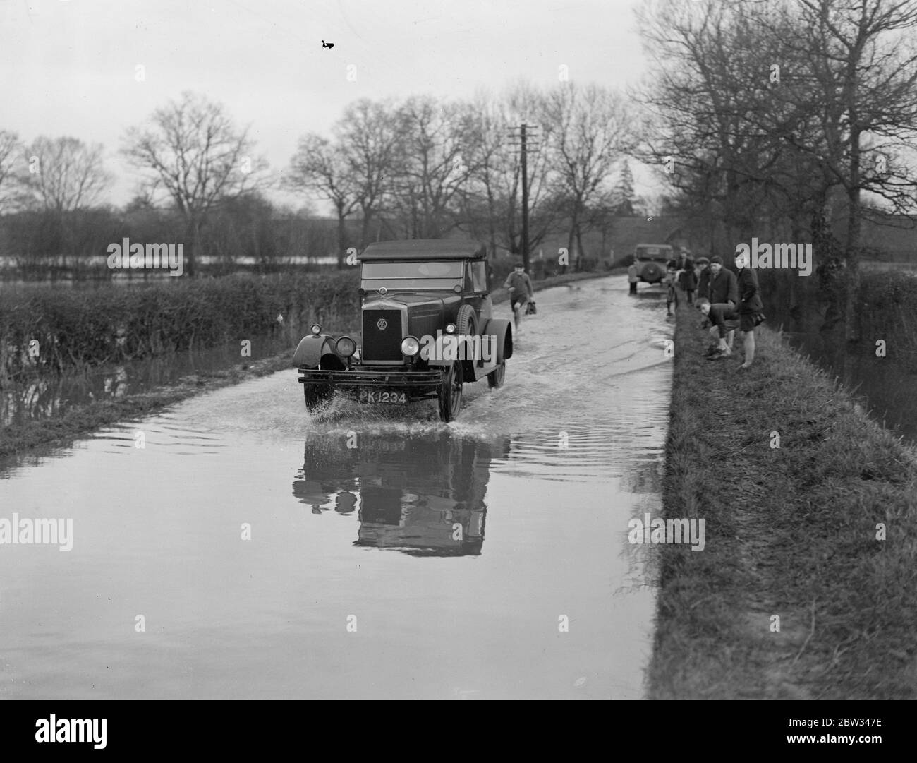 Le sud de l'Angleterre a été inondé après de grandes tempêtes . Tout le sud-ouest de l'Angleterre est inondé à la suite de fortes tempêtes qui ont rendu de nombreuses routes impraticables . Une voiture qui traverse des inondations sur la route Spinden , qui est presque impraticable . 3 mai 1932 Banque D'Images