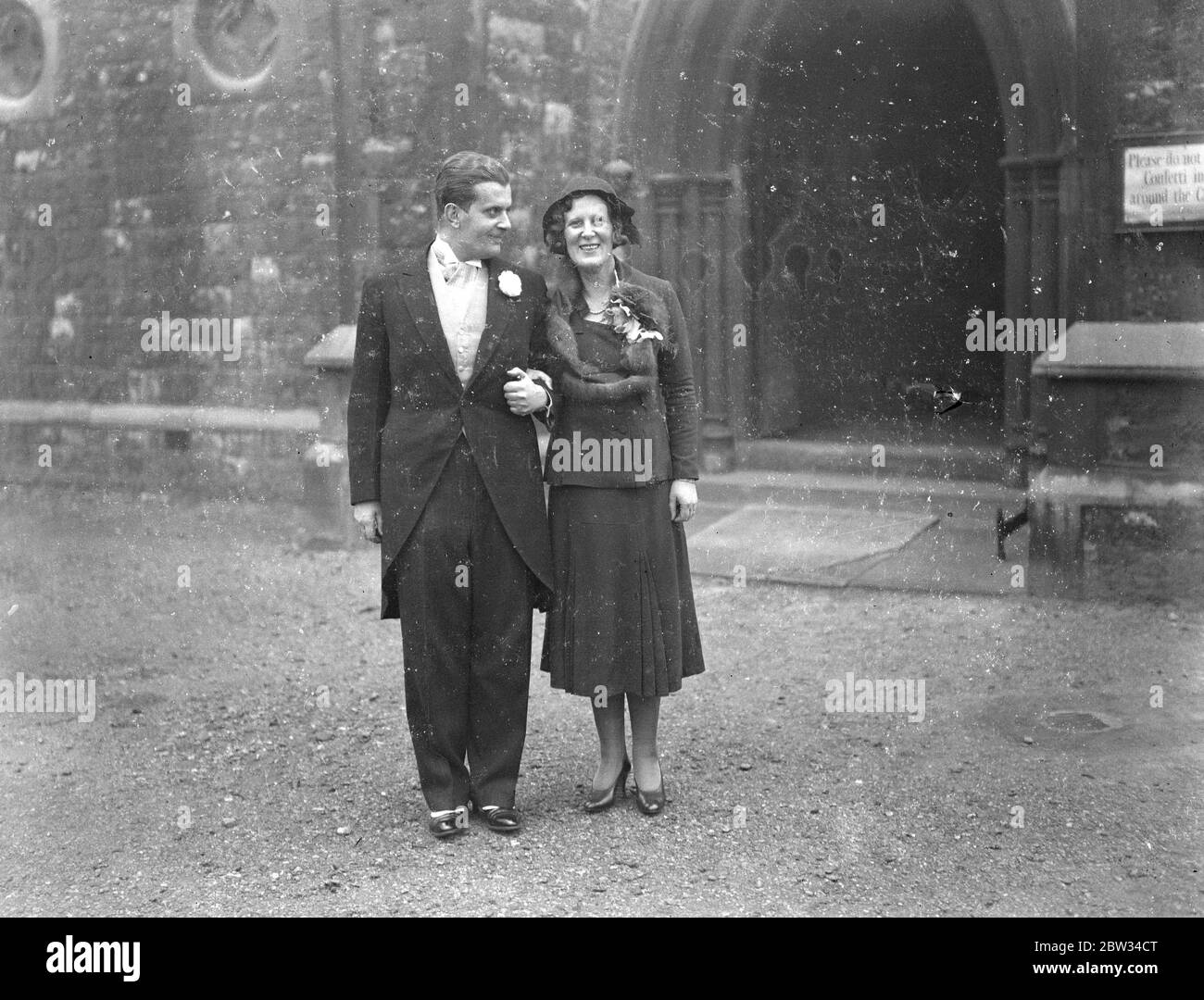 Le neveu de l'ancien ministre allemand se déllait dans le nord de Londres . Le mariage du Dr O G Lewald , neveu de Herr Lewald , ancien sous-secrétaire d'État allemand à l'intérieur , la Miss Evelyn Arden , a eu lieu à l'église St Peters , Belsize Park , Londres . La mariée et le marié étant filmés par un ami alors qu'ils quittaient l'église après la cérémonie . 30 janvier 1932 Banque D'Images