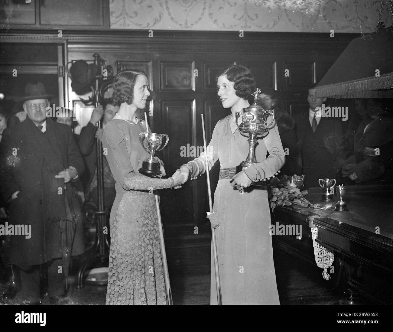 Mlle Joyce Gardner conserve le titre professionnel de championnat de billard . Mlle Joyce Gardner a défendu avec succès son titre de championne de billard professionnelle de femmes contre Mlle Ruth Harrison au Burwat Hall , Londres . ViscountessElibank présente la coupe de championnat à Mlle Joyce Gardner après sa victoire . Mlle Ruth Harrison , la deuxième à gauche . 25 février 1933 Banque D'Images