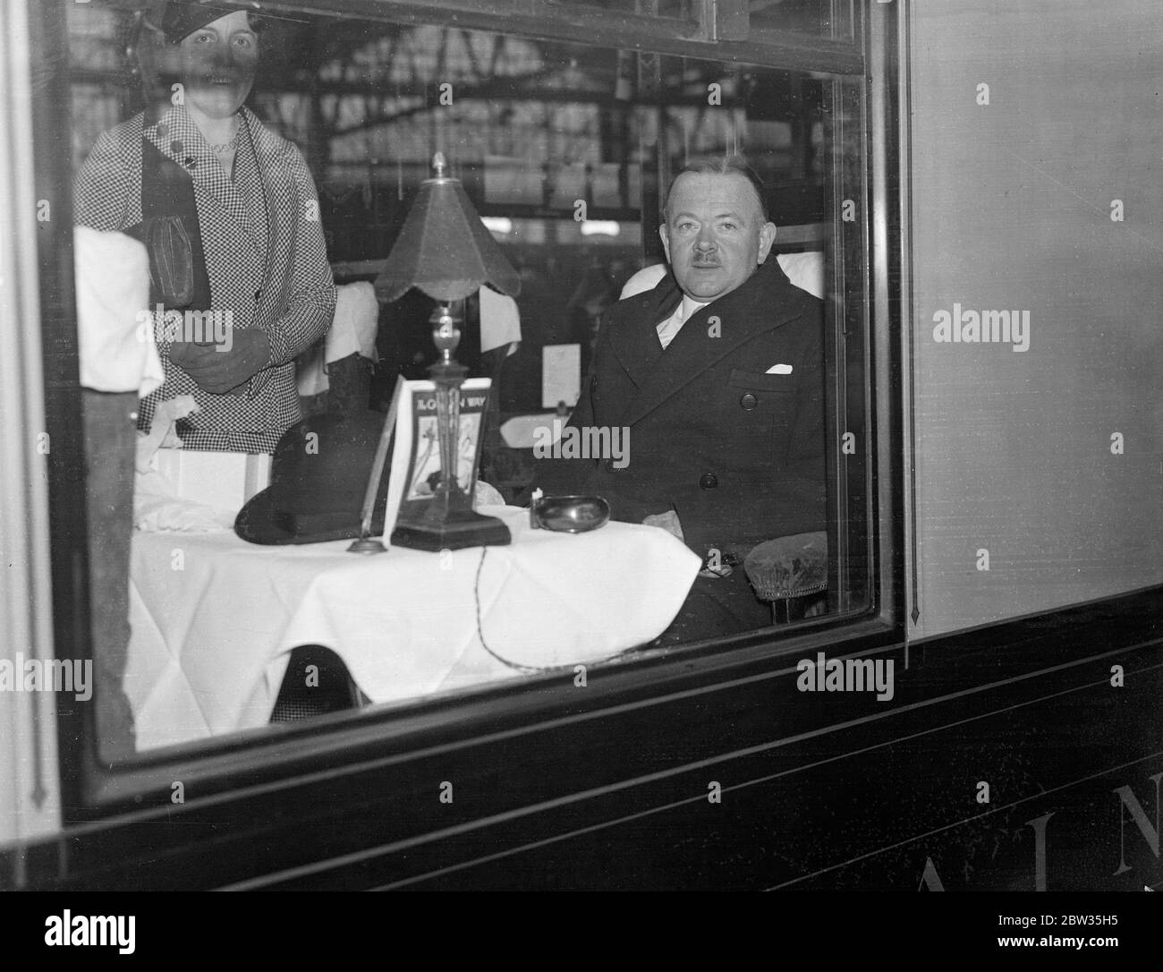 Un fonctionnaire britannique a prêté au Canada pour lancer un nouveau service de radiodiffusion . Le major Gladstone Murray de la British Broadcasting Company , est parti pour le Canada à bord de la SS Majestic pour conseiller la Commission de radiodiffusion canadienne sur l'organisation d'un service national de radiodiffusion pour le Canada . Il a été prêté au Canada à la demande de M. Pennet, Premier ministre du Canada . Le major Gladstone Murray assis à la table du train au départ de Waterloo pour Southampton . 15 mars 1933 Banque D'Images