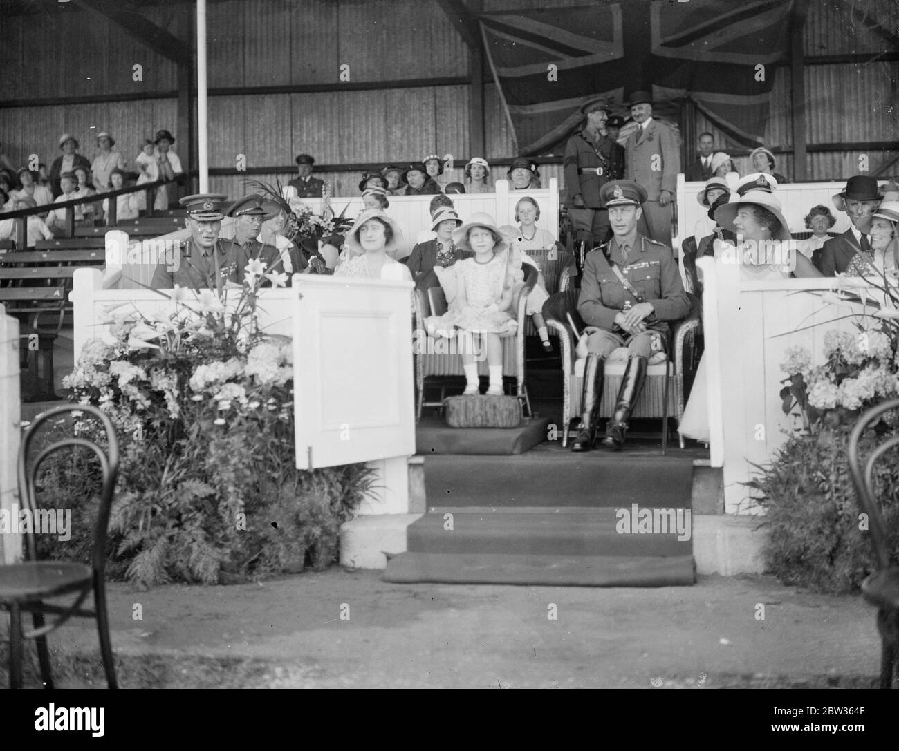 Princesse Elizabeth à Aldershot Tattoo . La princesse Elizabeth avec ses parents , le duc et la duchesse de York , regarda la robe complète , répétition de jour à Aldershot pour le Tattoo Aldershot . Des milliers d'écoliers étaient invités à la répétition. Photos ; la princesse Elizabeth avec le duc et la duchesse de York regardant la répétition . 7 juin 1933 Banque D'Images