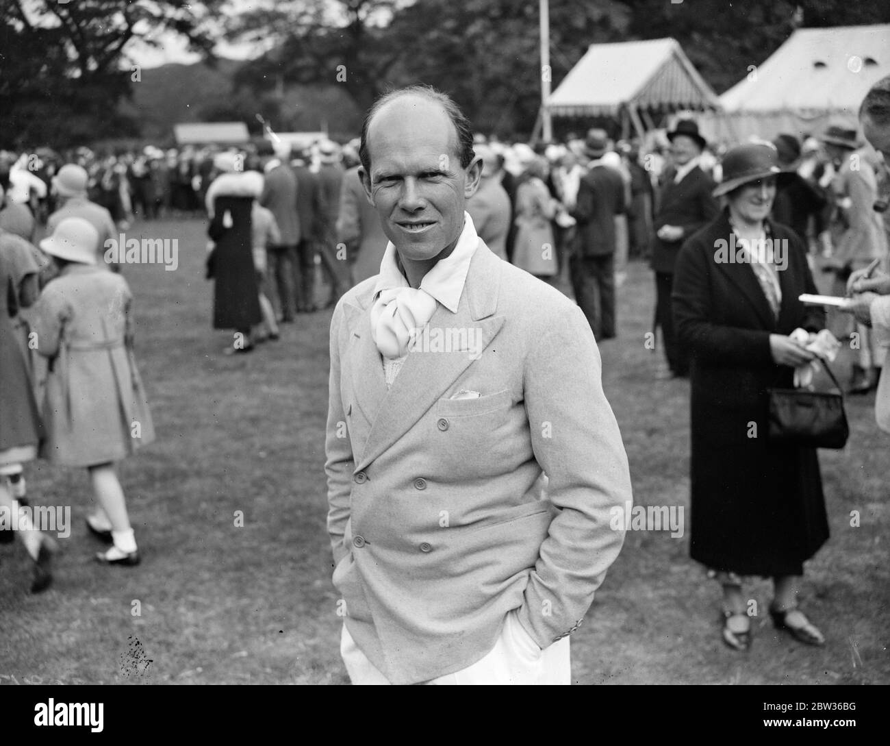 Auteur Alec Waugh lors d'un événement en plein air avec des foules et des tentes en arrière-plan Banque D'Images