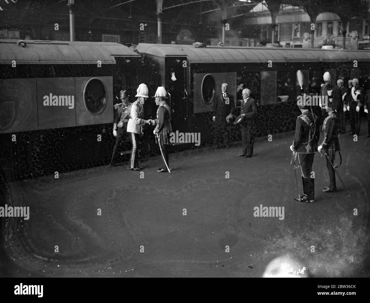 Le roi et le prince de Galles accueillent le roi Feisal lors de sa première visite d'État . Le Roi et le Prince de Galles étaient à Victoria Station , Londres , pour accueillir le Roi Feisal d'Irak lors de sa première visite d'État en Angleterre . Un garde d'honneur du 2e Bataillon Grenadier Guards , avec la couleur du roi et la bande du régiment , ont été montés à la gare Victoria , et les rues le long de la route vers le Palais de Buckingham ont été bordées de troupes . Le duc de York avait accompagné le roi Feisal de Douvres . Des expositions de photos , le roi George et le prince de Galles rencontrent le train du roi Feisal à la gare Victoria le 20 juin Banque D'Images