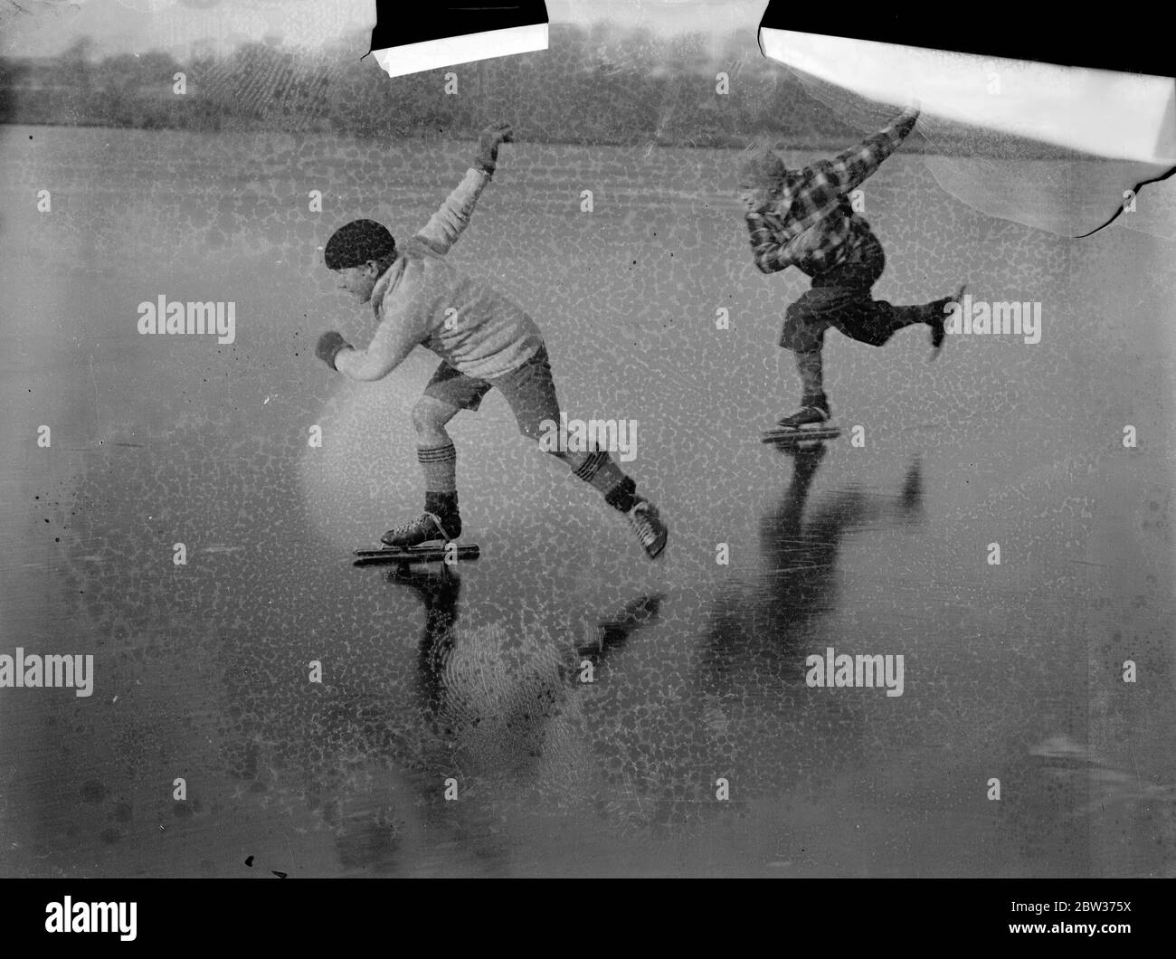 Ancien champion pratique pour les compétitions de patinage britannique à Rickmansworth . M. L T Redburn , ancien champion de patinage amateur de Londres , Et son fils Bobbie , 10 ans , sur la glace à l'Aquadrome , Rickmansworth , où M. Redburn a pratiqué pour le Championnat amateur de One Mile London de la National Skating Association et le Championnat britannique de Quarter Mile qui se déroule demain . 14 décembre 1933 Banque D'Images