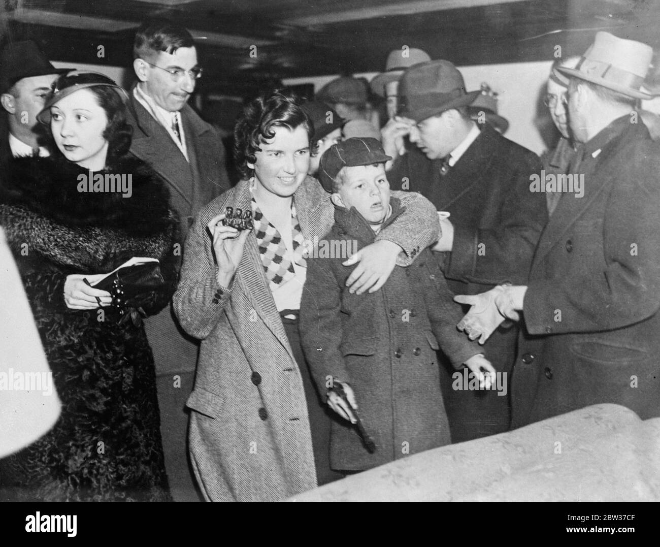 Nila Cram Cook , fille du regretté George Cram Cook , poète , dramaturge et érudit grec , Qui a déserté la vie d'un séminaire ascétique du Mahatma Gandhi au Cachemire , est arrivé à New York à bord de la ville cargo d'Elwood , elle avait été placée de force à bord du navire à Calcutta . Nila Cram Cook dit qu'elle a quitté Gandhi pour chercher de nouveaux thriments , ' la vie , l'amour et la musique ' . Photos Nila Cram Cook avec son fils , Serios Cram , à l'arrivée à New York . 30 mars 1934 Banque D'Images