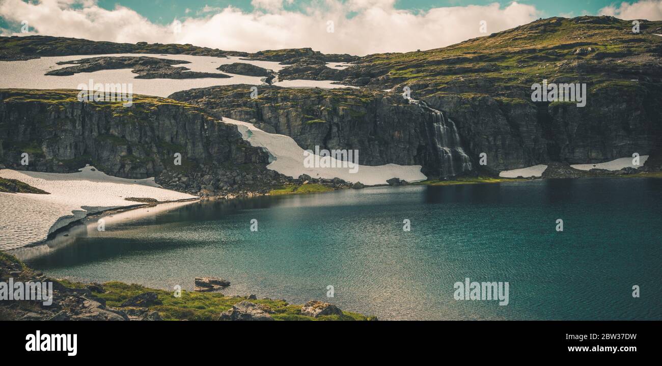 Paysage scandinave naturel des Rocheuses avec lac, champs de glace et chute d'eau. Région alpine du Sud-Ouest de la Norvège. Panoramique été photo. Banque D'Images