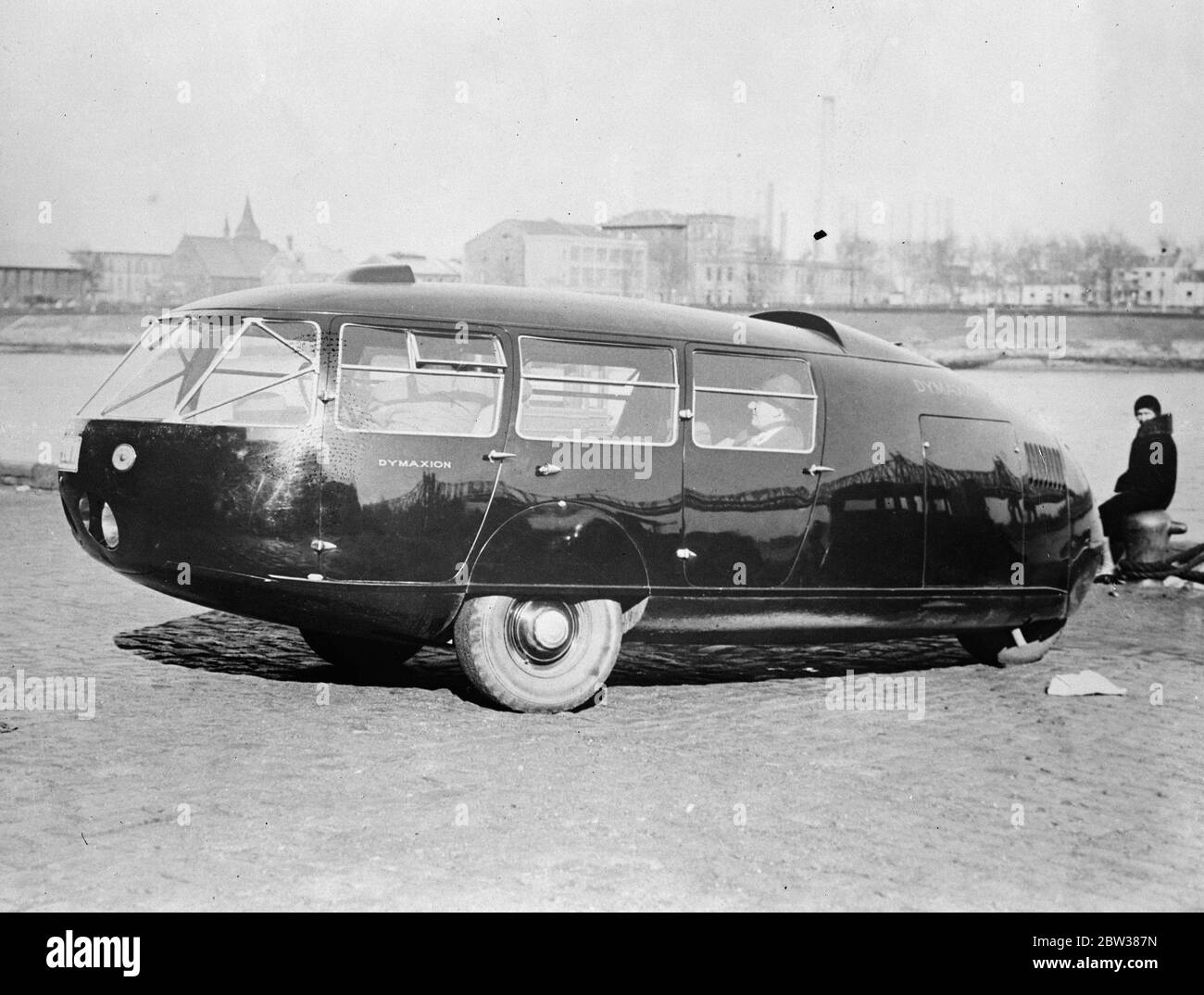 La voiture du futur . Une voiture à trois roues avec l'apparence d'un raindrop noir allongé appelé le Dymaxion a été inventé par Buckminster Fuller , un américain . il est profilé , a deux roues avant à mi-chemin dans le corps ovaloid et une roue arrière , mis dans la queue . La roue arrière dirige la voiture , agissant précisément comme le gouvernail d'un navire . La voiture peut atteindre une vitesse de 125 miles par heure . Un dispositif périscopique alimente le rétroviseur arrière habituel . Le moteur est monté à l'arrière , mais entraîne les roues avant . Photos montre , la Dymaxion . 11 mai 1934 Banque D'Images