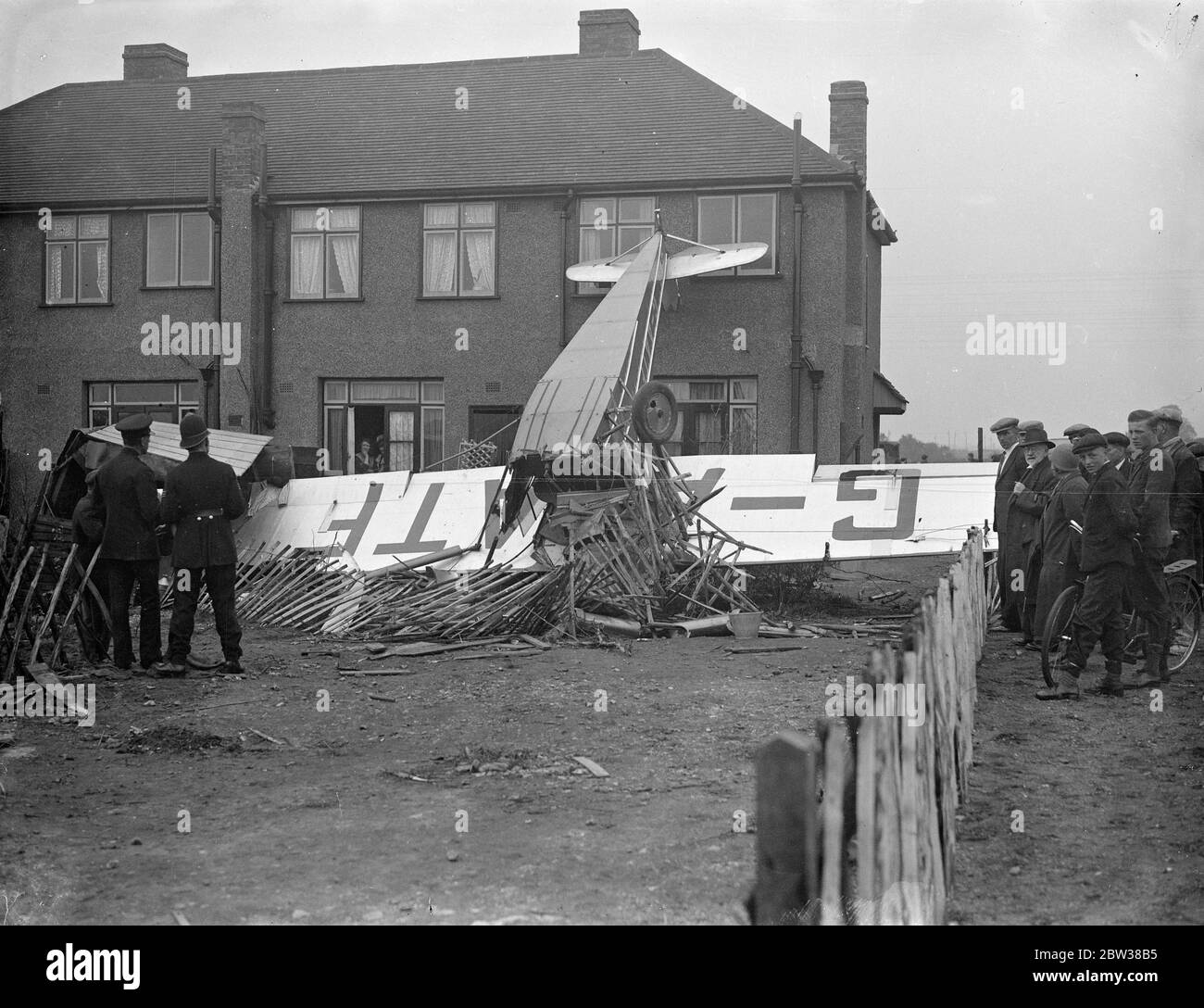 Deux sont emmenés à l'hôpital quand l'avion s'écrase dans la maison après avoir quitté l'aérodrome . Un avion qui venait de quitter l'aérodrome de Hanworth s'est écrasé dans une clôture et a frappé l'arrière d'une maison . La machine a alors renversé . Un passager a été jeté . deux occupants ont été emmenés à l'hôpital . Photos montre , l'avion dans le jardin de la maison après l'accident . 9 mai 1934 Banque D'Images