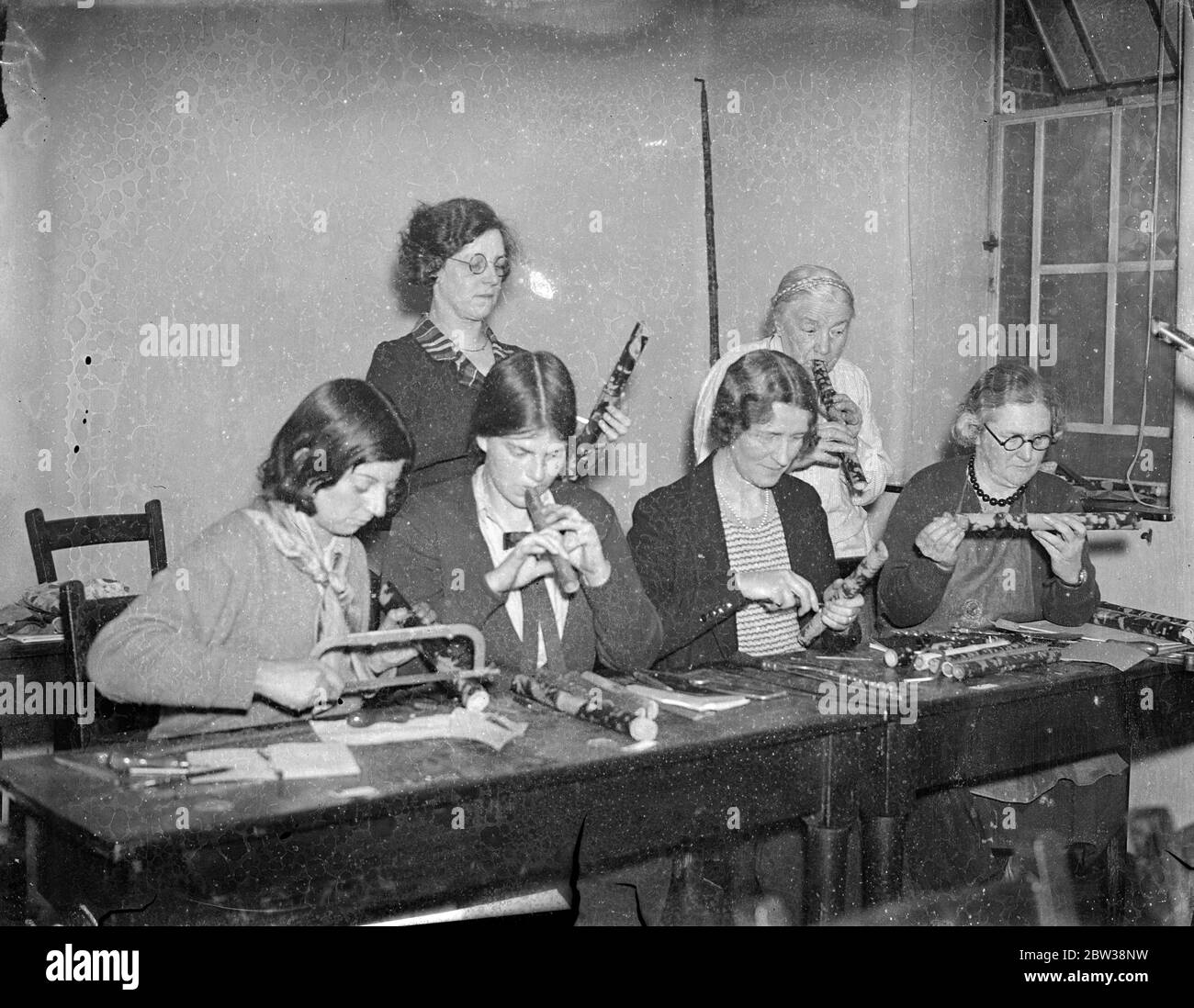 Les adeptes des tuyaux de PAN comme étudiants à l'école de vacances de Londres . Une des plus étranges écoles de vacances jamais tenues est en cours à Bedford College , dont il y a plus d'une centaine , sont dévotés des tuyaux de PAN , et le cours auquel ils sont présents a été organisé par les cornemuses ' guild ' . La guilde a été formée il y a un peu plus d'un an ' pour faire plus loin l'artisanat triple , de faire , décorer , jouer , chaque homme a ses propres instruments ' avant que quiconque puisse être membre , Il ou elle doit signer un formulaire indiquant ' J'ai fait et joué mon propre pipe . ' . Photos ; fabrication de tuyaux et dru Banque D'Images