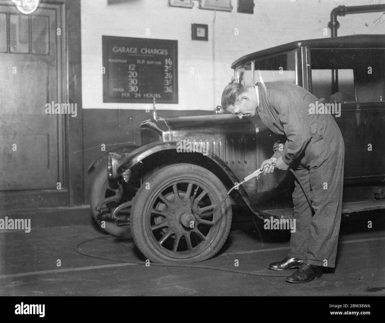 Le garage le plus à jour du monde. Ce qui est prétendu être le garage le plus à jour dans le monde poursuit sa carrière super efficace près de la salle d'exposition Olympia au coeur de Londres . À ce garage ils font des choses à grande échelle . Ils fournissent toutes les marques d'essence auxquelles les automobilistes sont susceptibles de penser , pas moins de dix-huit marques d'huile . Ils ont un compresseur élaboré pour pomper l'huile de la salle de stockage au garage . Les voitures sont nettoyées par le dernier instrument de vide électrique , qui élimine toutes les particules de poussière du véhicule et lui donne , une fois de plus , le Banque D'Images