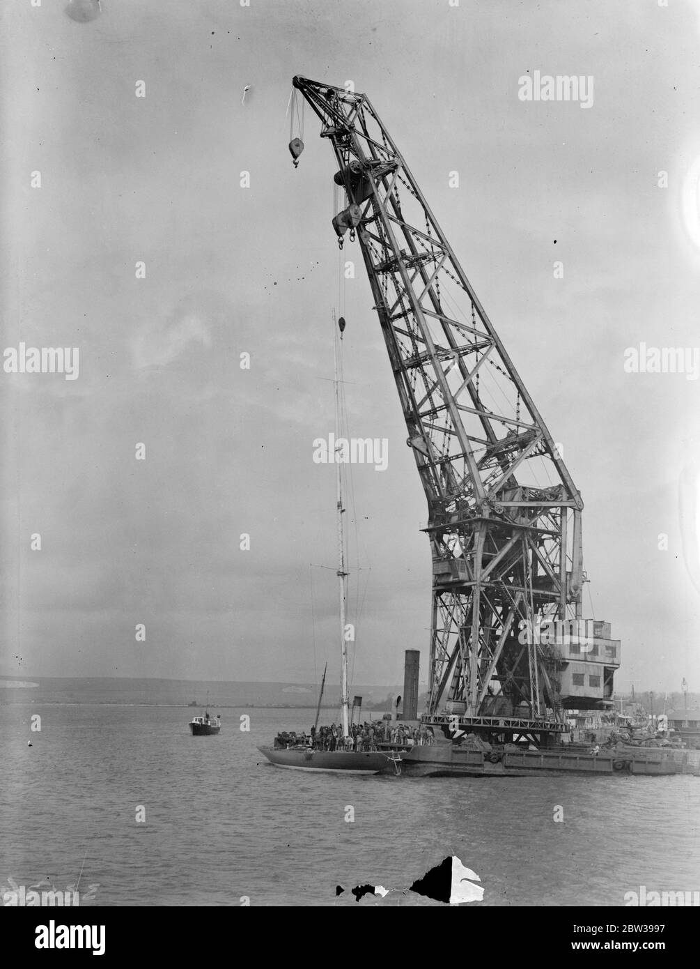 Marcher le mât de l'effort au Royal Dockyard à Portsmouth . La tâche de marcher l'énorme mât en acier du yacht Endeavour , qui vient d'être lancé à Gosport , a été achevée avec l'aide d'une grue énorme au chantier naval Royal de Portsmouth . Le bateau de M. ' Tommy ' Sopowy ' sera en compétition pour la coupe de l'Amérique en septembre. Photos montre ; la grue abaissant l'énorme mât en acier en position dans le chantier naval Royal de Portsmouth . 19 avril 1934 30, 30, 30, 30, 30, 30, 30, 30, 30, 30 Banque D'Images