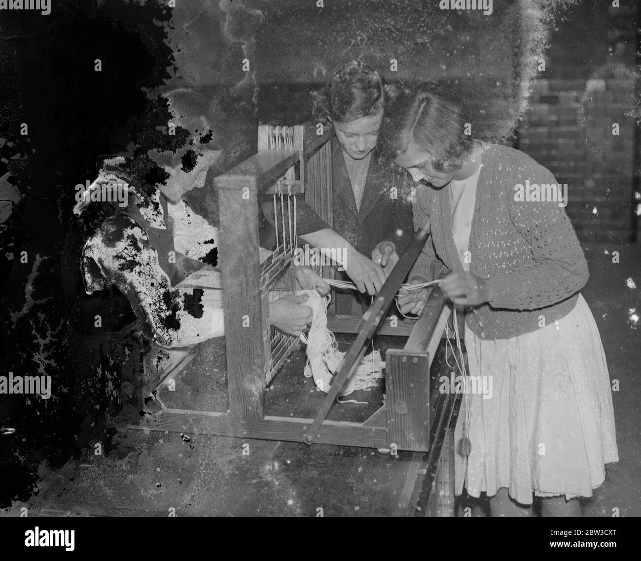L'école la plus à jour de Londres . Les filles apprennent à tisser sur des métiers . Les chercheurs se tissage sur une table main métier . 16 octobre 1935 Banque D'Images