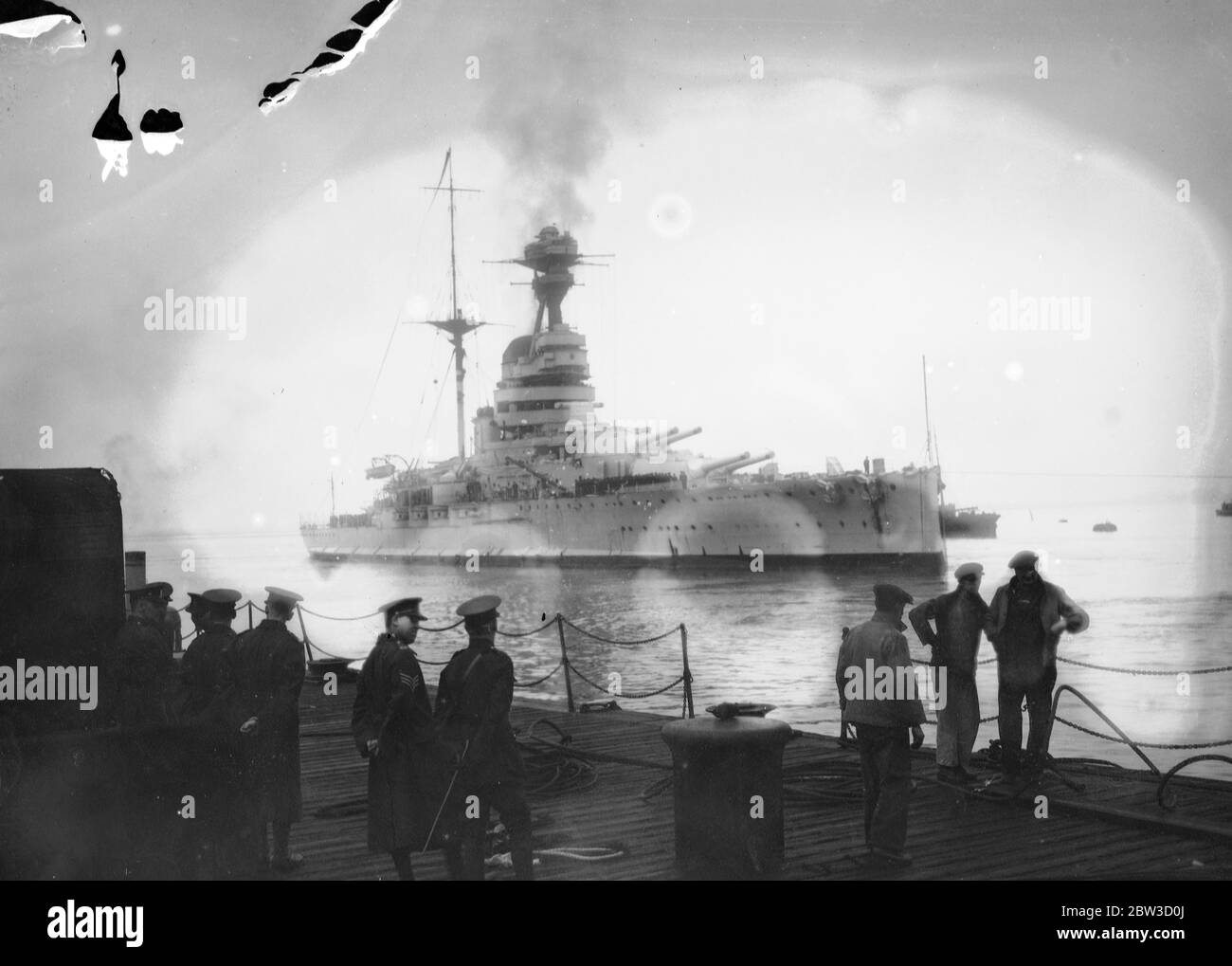 Cuirassé maison de la méditerranée . Les marins passeront noël en Angleterre . Le navire de guerre HMS Resolution (numéro 09 ) de 29 , 150 tonnes est arrivé à Porstmouth d'Alexandrie après avoir terminé plus de deux ans de service sur la station méditerranéenne . Beaucoup de marins d'autres navires de guerre étaient à bord d'elle ainsi que son propre équipage pour qu'ils puissent passer noël à la maison . La résolution bes du HMS a été relevée par le HMS Ramillies ( 07 ), qui est de classe et de tonnage similaires . Photos spectacles , HMS résolution arrivant à Portsmouth . 5 novembre 1935 Banque D'Images