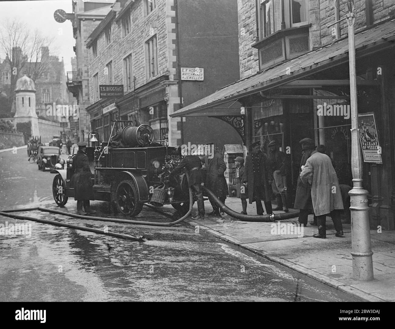 Les pompiers pompent de l'eau dans les magasins à la suite de graves inondations à Swanage . Pompiers pompant l'eau d'un magasin inondé dans la rue High à Swanage , Dorset . 19 novembre 1935 Banque D'Images