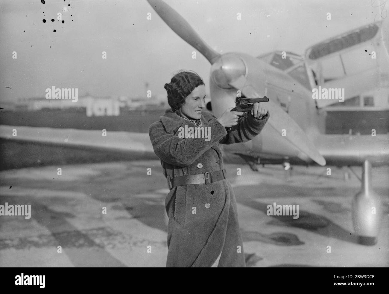 Jean Batten première aviatrice à tenter de traverser l'Atlantique Sud - décollage de Hatfield . Mlle Jean Batten testant son revolver avant de quitter Hatfield . Elle est obligée d'en avoir un par les autorités françaises . 9 novembre 1935 Banque D'Images