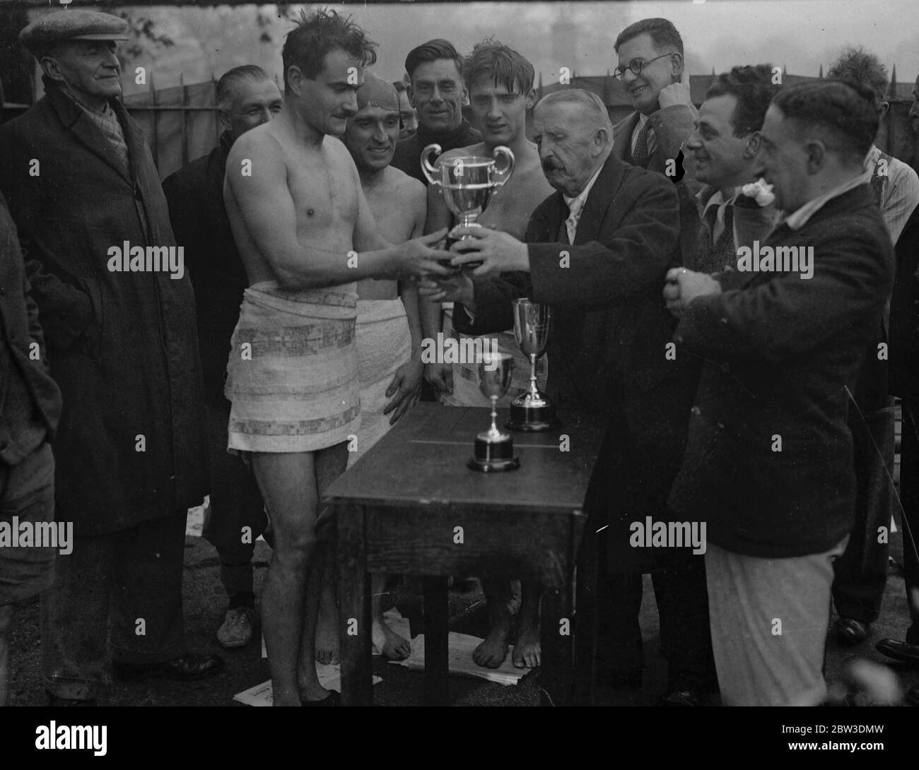 Nage en serpentin le matin le plus froid de l'année. Applaudisser UN J Goffrey , après sa victoire . A gauche de Goffrey est Tom Carmody ( avec le trophée pour la deuxième place ) , et à droite est K N Wood ( avec le trophée pour la troisième place ) . 21 octobre 1935 Banque D'Images