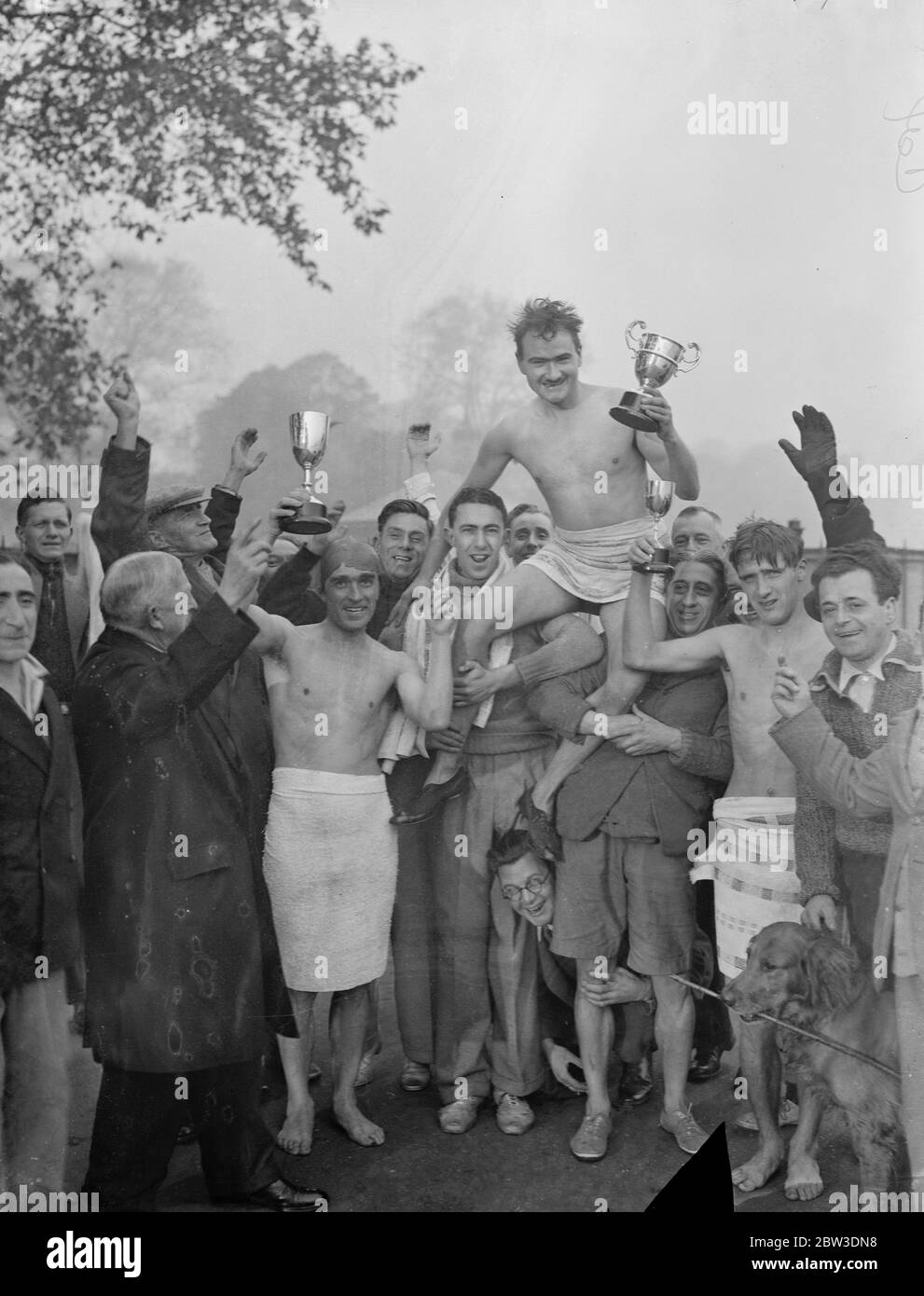 Nage en serpentin le matin le plus froid de l'année. Applaudisser UN J Goffrey , après sa victoire . A gauche de Goffrey est Tom Carmody ( avec le trophée pour la deuxième place ) , et à droite est K N Wood ( avec le trophée pour la troisième place ) . 21 octobre 1935 Banque D'Images