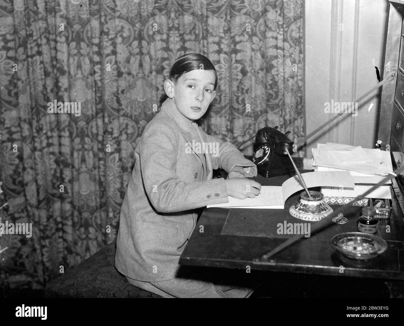 Écrire son troisième livre à 11 ans . Un garçon de Londres avec un cadeau étonnant a acheté une machine à écrire avec des redevances . Robert Holland travaille sur son nouveau livre avec sa machine à écrire . 21 décembre 1935 Banque D'Images