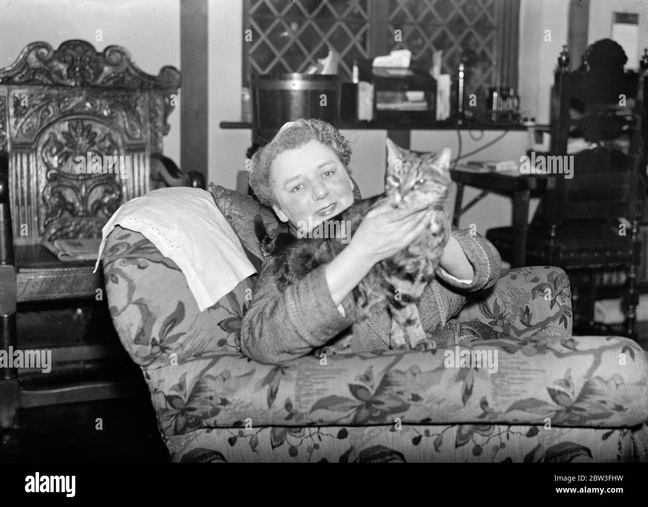 Bien fait ' Minnie ' , le plus vieux chat de Londres fête son vingt - premier anniversaire . Photos ; Minnie , le plus vieux chat de Londres dans les bras de Mme V C Wellington , son propriétaire . 30 janvier 1935 Banque D'Images