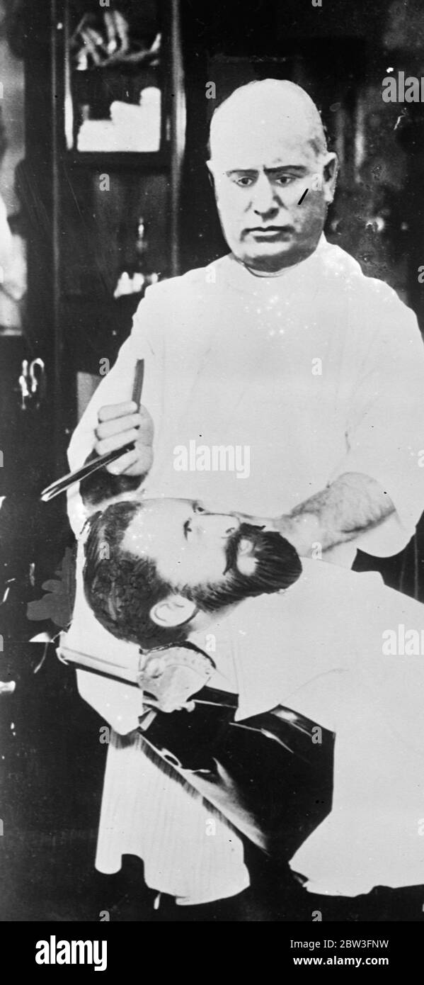 Haile Selassie est dans la chaise de coiffure de Mussolini . L'Amérique fête le premier avril . C'est ainsi que l'Amérique considère la situation difficile de l'empereur Haile Selassie d'Abyssinia , contre lequel la marée de la guerre semble tourner . L'image , un composite , est publiée dans les journaux américains comme une plaisanterie de la journée d'avril Fool . Il montre Mussolini , avec un visage sans réserve , tenant un rasoir sur l'empereur Haile Selassie , allongé à sa miséricorde dans la chaise du barber . L'empereur semble conscient de son danger . 1er avril 1935 Banque D'Images