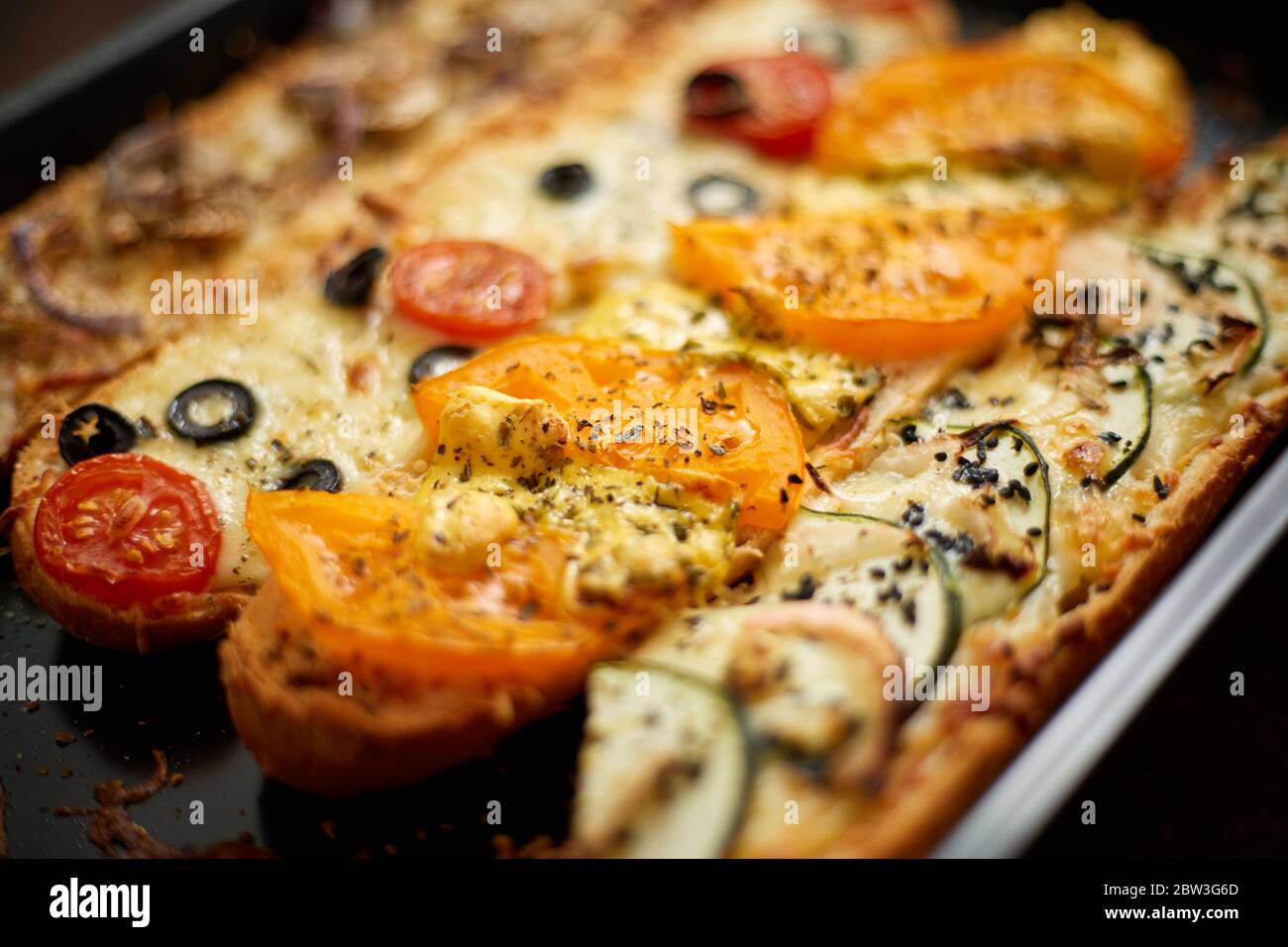 Longues baguettes de pizza avec thon, champignons, tomates et fromage sur un plateau métallique Banque D'Images