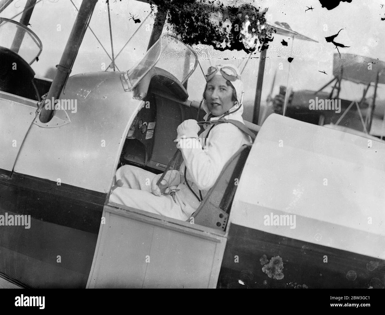 La première femme d'Angleterre acrobat rejoint le cirque aérien de l'Australie flyer . Fille du docteur Quads . Les premières femmes d'Angleterre acrobat , Mme Winifred Crossley , fille du Dr E R Harrison , le médecin qui a assisté à la naissance des quadriplets de St Neot a rejoint le cirque aérien de M. C W A Scott et doit visiter la Grande-Bretagne . Elle prépare à l'aérodrome de Hanworth avec son fils John, âgé de neuf ans et demi, pour la tournée qui commence demain ( mercredi ) . John l'accompagne sur tous ses vols . Photos , Mme Winifred Crossley dans le cockpit de son avion à l'aérodrome de Hansworth , où elle est p Banque D'Images